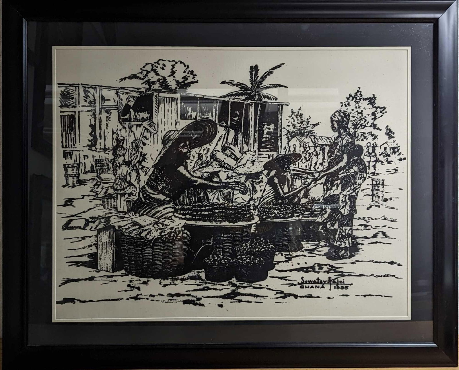 Framed Sowatey Adjei Tomato Sellers Ghana Print: Framed Sowatey Adjei Tomato Sellers Ghana Print. Wearing over sized hats, women sit by their stalls in Accra's Makola market. They are surrounded by baskets filled with tomatoes, enticing customer