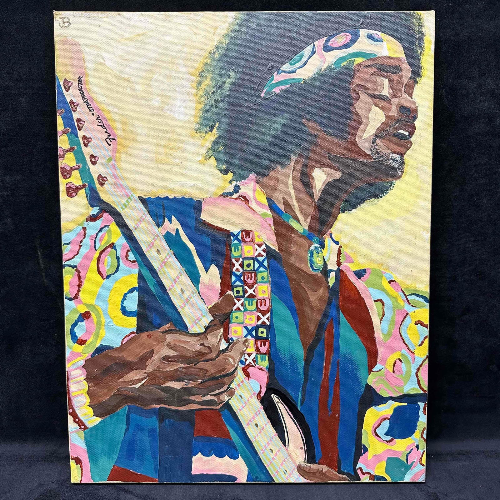 Jimi Hendrix Inspired Stylized Portrait Painting on Canvas: Unknown artist signed JB and marked 2021. This vibrant artwork depicts an inspired style portrait of rock legend Jimi Hendrix playing a Fender Stratocaster guitar. This item is in good pre-owned,