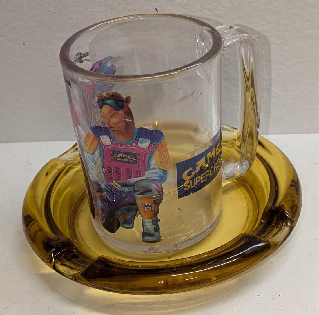 Plastic Camel Supercross Mug & Cigar Ashtray: Plastic Camel Supercross Mug & Cigar Ashtray. This lot includes: (1) Plastic Camel Supercross Mug. This is approx 5" x 4" x 5 1/8". The mug has markings and scratches. (1) Vintage Lar