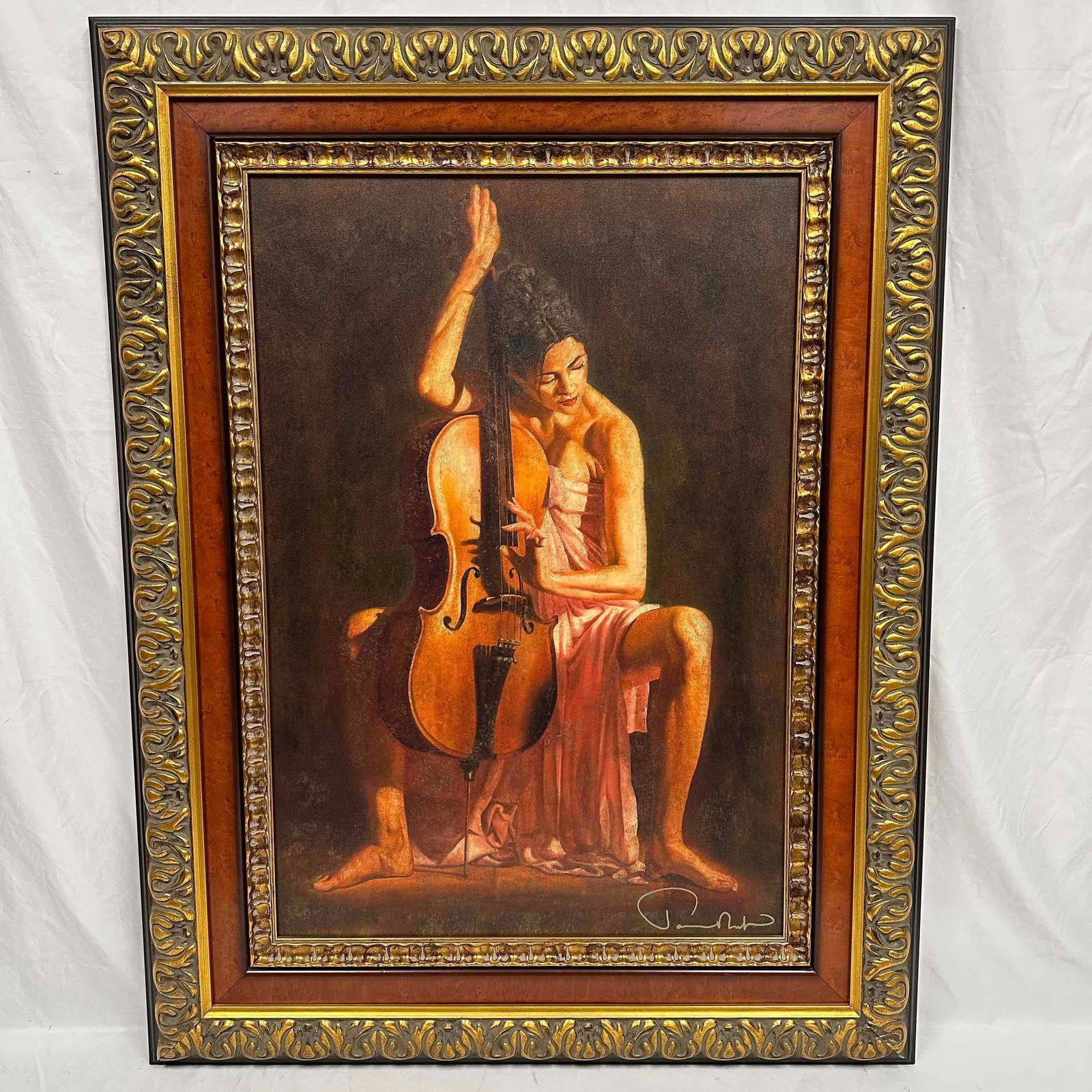 Tomasz Rut Vocalisa Pink Dress Woman Playing Cello Framed Giclee on Canvas: The framed giclee on canvas depicts a woman in a flowing, light colored dress, likely pink or peach, seated with a cello. The artwork is framed in an ornate, dark wood frame with gold accents. Large s