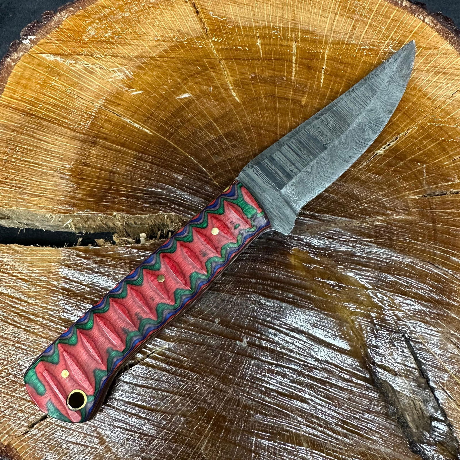 MHS Cutlery Fixed Steel Blade Knife P72 Purple Red Green Handle: Fixed blade knife by MHS Cutlery featuring a patterned steel blade with a curved profile. The textured, carved handle is constructed with multi-tone stabilized epoxy resin/wood material in purple, gre