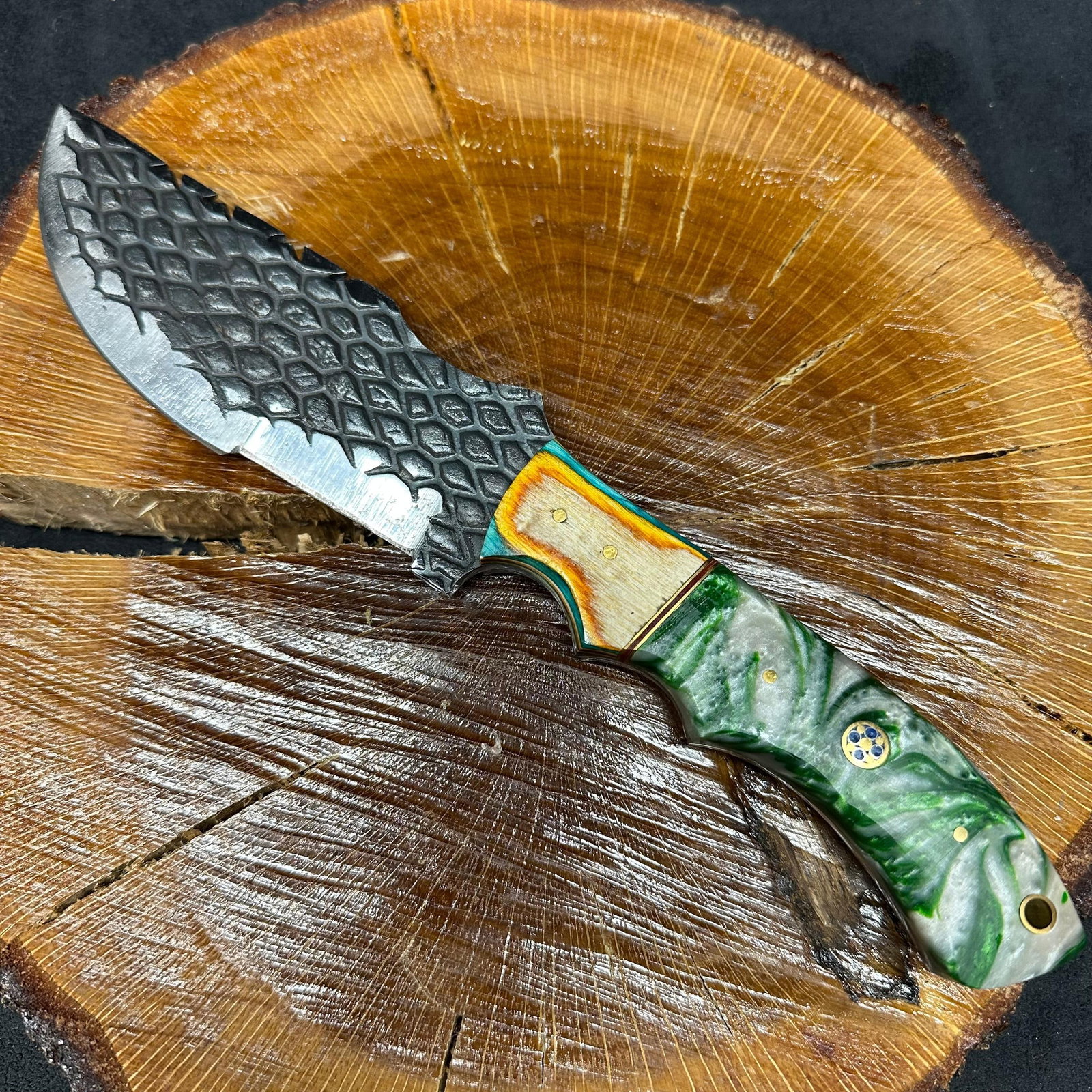MHS Cutlery Fixed Textured Blade Knife Green Resin Style Handle and Leather Sheath P76: Fixed large blade knife by MHS Cutlery featuring a patterned steel blade with a straight profile. The handle is constructed with multi-tone stabilized epoxy resin/wood material in green and white hues