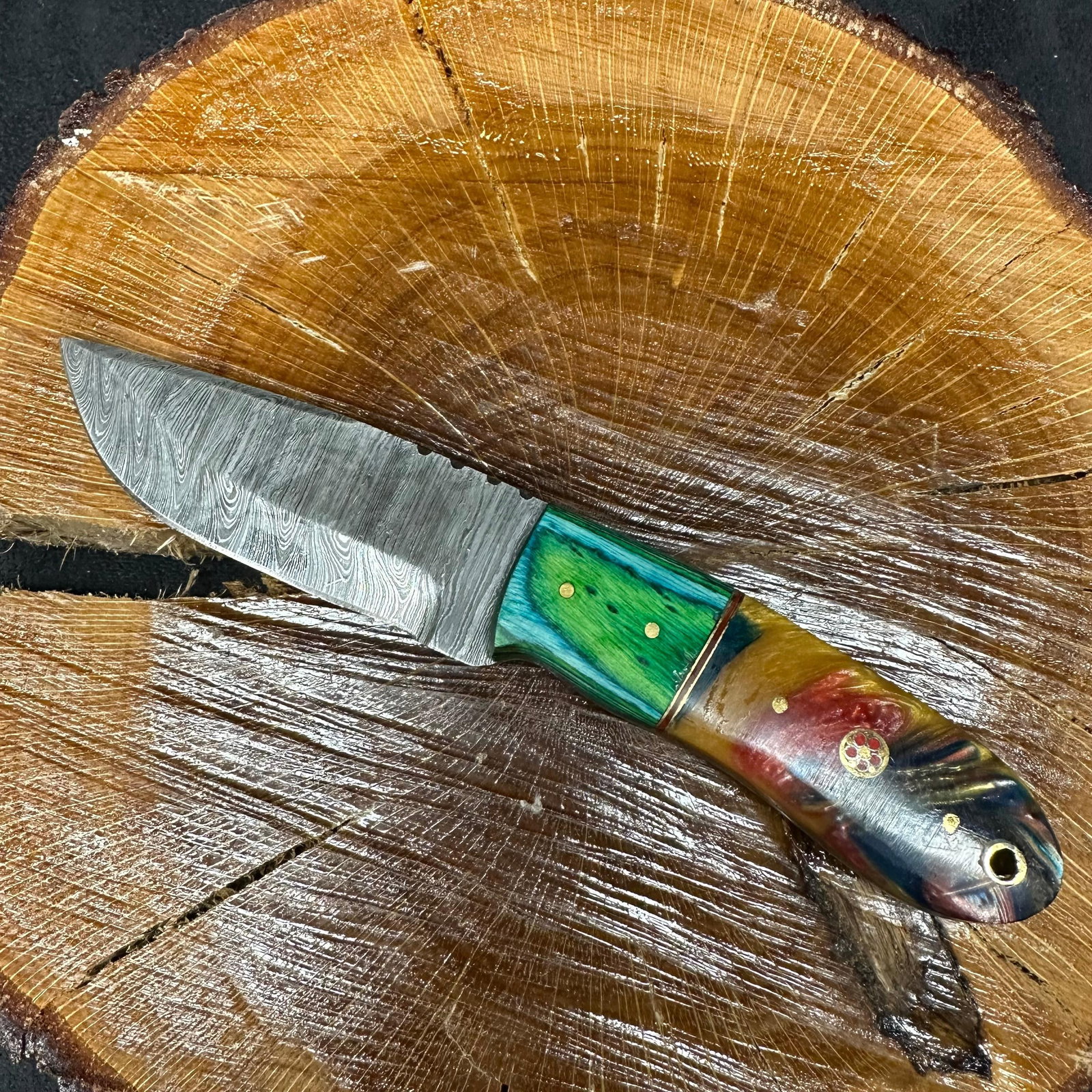 Two Colorway Design Handle MHS Cutlery Fixed Blade Knife P83: Fixed blade knife by MHS Cutlery featuring a layered patterned steel blade and decorative spine work. The handle features a contoured, wood/epoxy resin-style grip with two colorway designs with metal