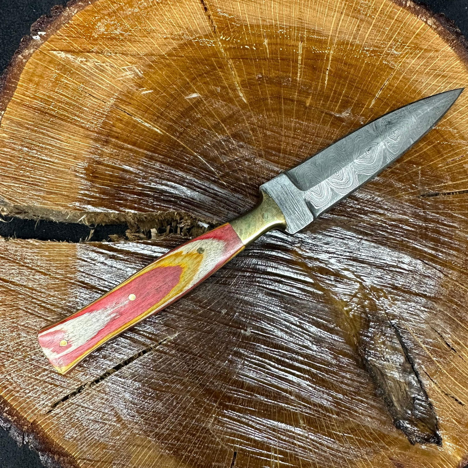 MHS Cutlery Fixed Blade Knife Dagger Style P89 with Leather Sheath: Fixed dagger-style blade knife by MHS Cutlery featuring a textured steel blade and decorative spine work. The handle has a contoured, multi-colored wood/epoxy resin-style grip with metal mosaic pin ac