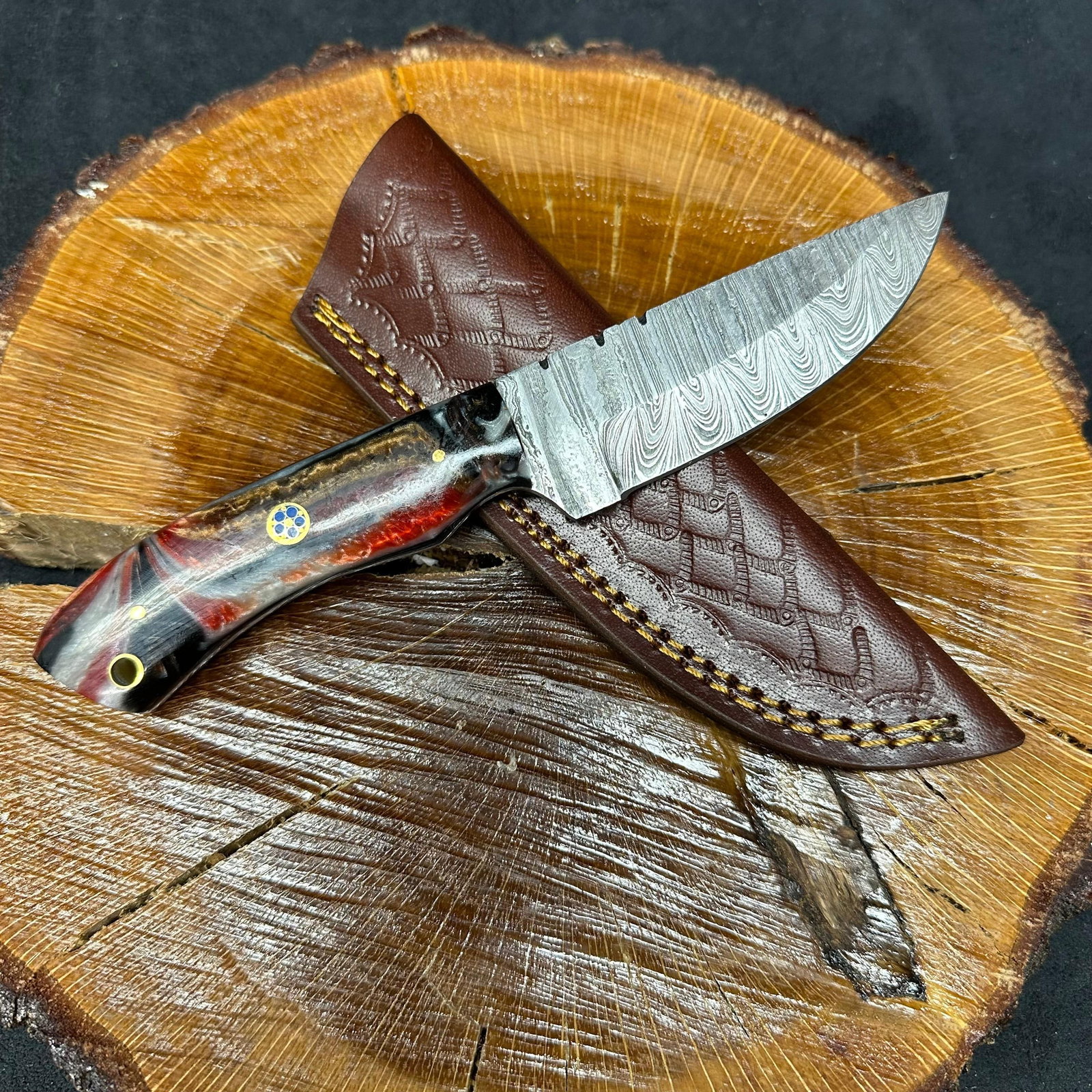 Black and Red Colorway Handle MHS Cutlery Fixed Blade Knife P97: Fixed blade knife by MHS Cutlery featuring a textured steel blade and decorative spine work. The handle has a contoured, multi-colored wood/epoxy resin-style grip with metal mosaic pin accents. Includ