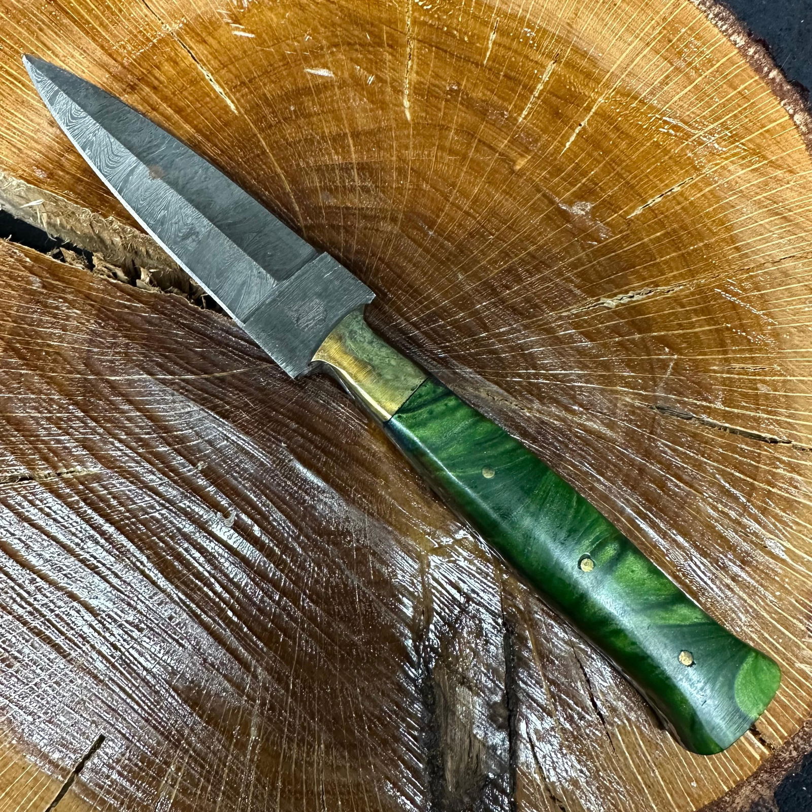 Green Handle Dagger Style MHS Cutlery Steel Fixed Blade Knife P70: Fixed dagger-style blade knife by MHS Cutlery featuring a textured steel blade and decorative spine work. The handle has a contoured, green-colored epoxy resin-style grip with metal mosaic pin accents
