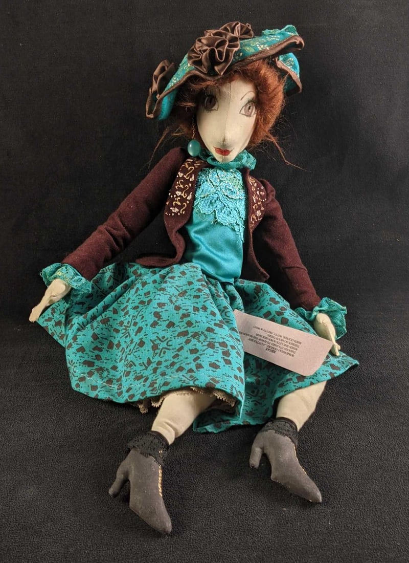 Handmade Cloth Doll: Handmade Cloth Doll This doll looks to be completely handmade. It is in good condition with no known damage just a missing earring. There is a name tag and a small description of the doll's name a