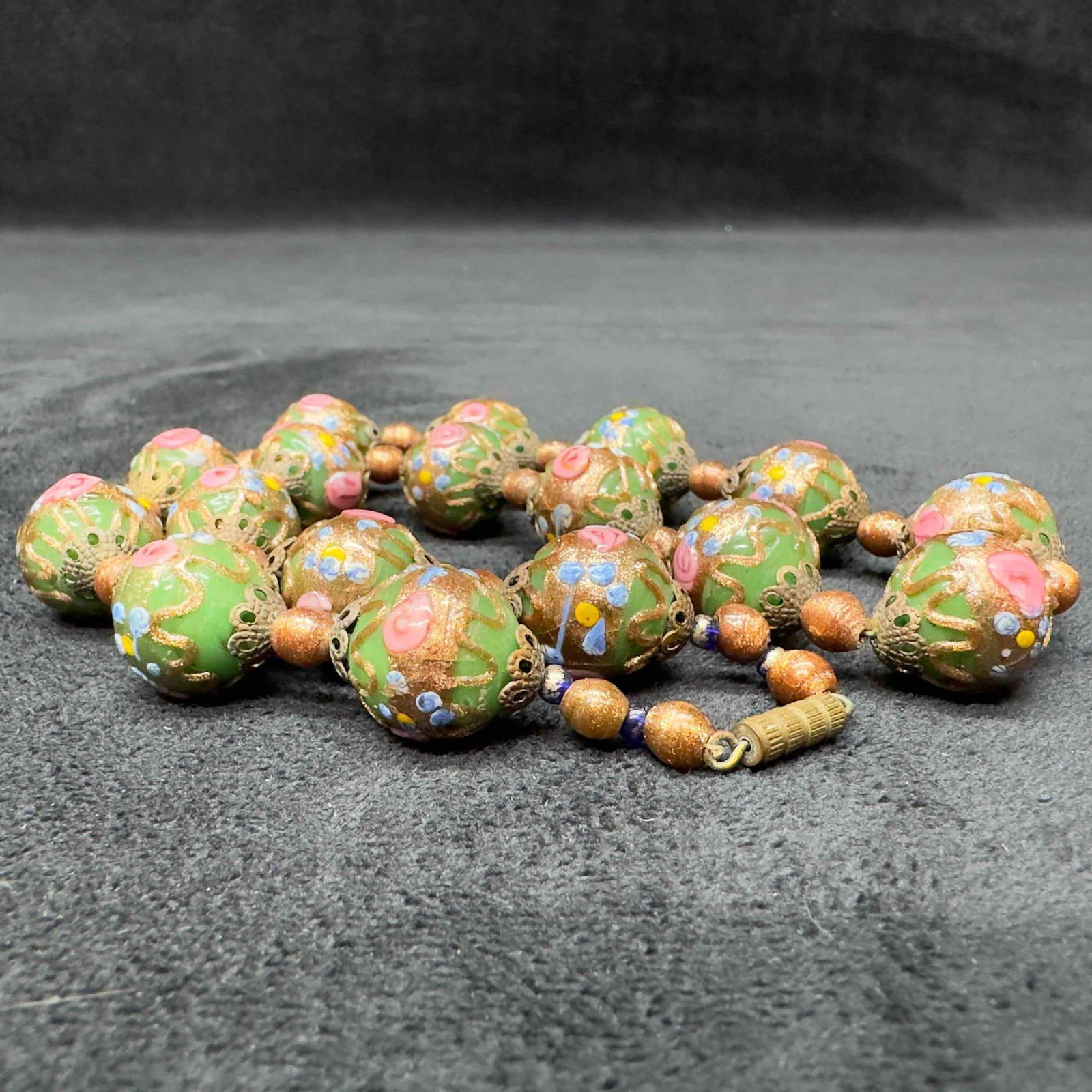Venetian Murano Lamp Work Glass Green Round Bead Fiorato Floral Beaded Copper Accents Necklace A92: Venetian Murano Lamp Work Glass Green Round Bead Fiorato Floral Beaded Copper Accents Necklace A92. Necklace with green glass beads with beautiful designs on each. The necklace features copper and flo