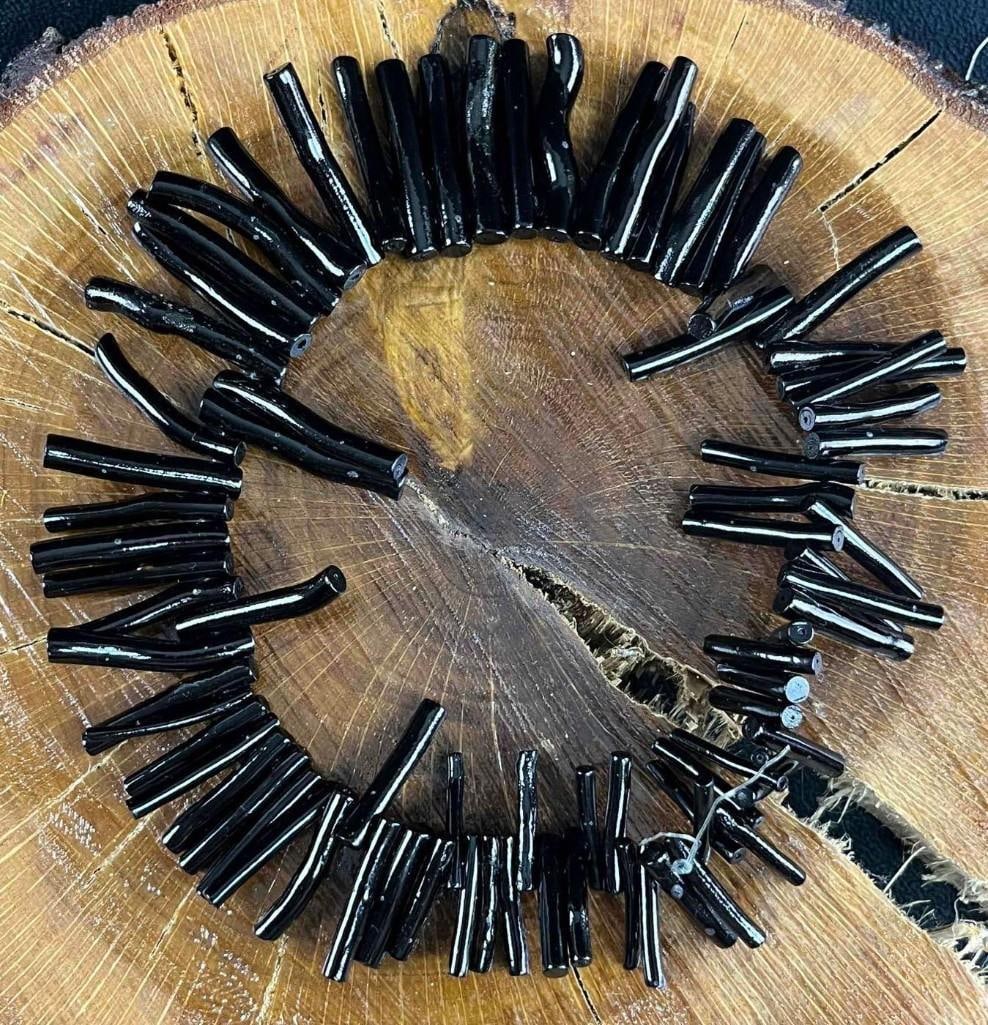 Coral Black Dyed Coral Beads: Coral Black Dyed Coral Beads. These are black-dyed coral beads with a shiny finish. These beads are in good condition and may have experienced slight wear. The coral is all strung off a plastic cord a