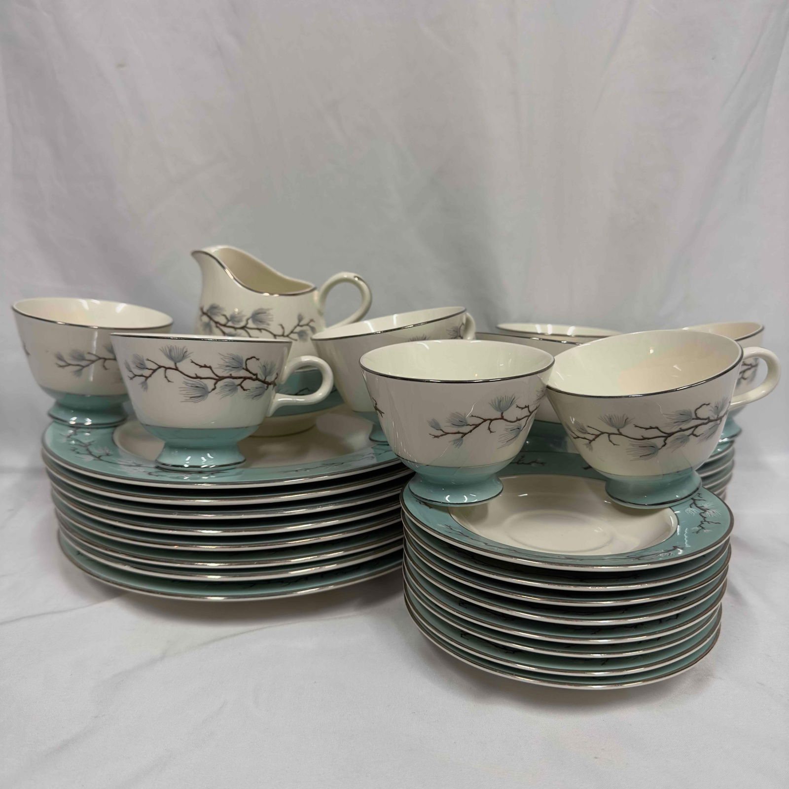 Vintage Cavalier Eggshell Homer Laughlin Turquoise Line Leaves Romance 33 Piece Set: The lot features a 33 piece set Romance Pattern by Homer Laughlin. Manufactured by Cavalier U.S.A. The floral design surrounded by leaves enhances the turquoise trim and silver trim. This set includes