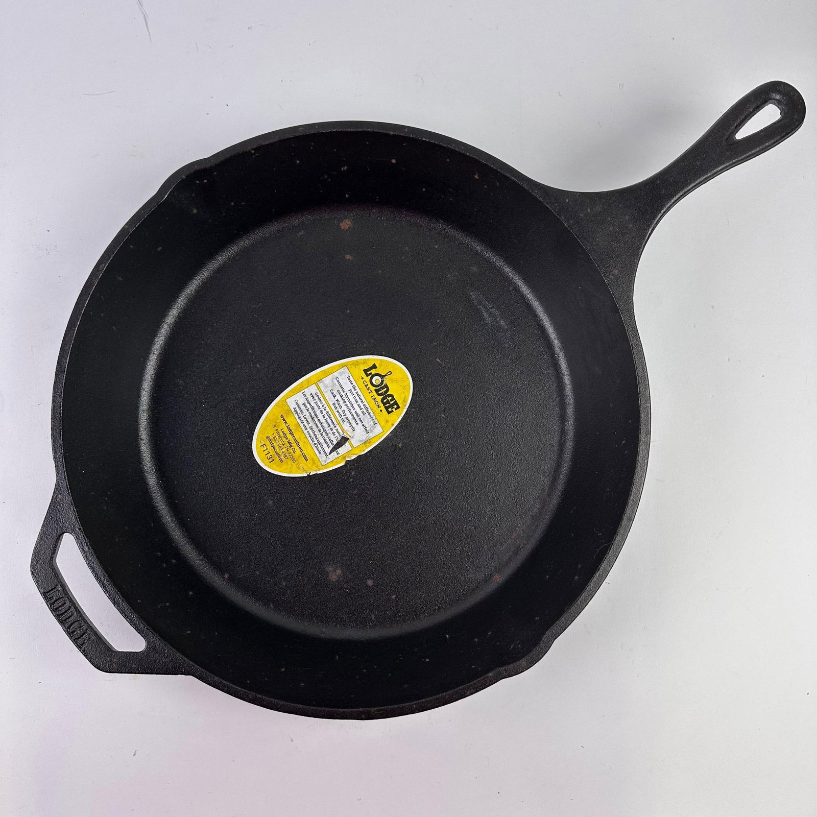 Lodge 12 Inch Cast Iron Pre-Seasoned Skillet Signature Teardrop Handle Holder: Minor discoloring, staining, or rust spots are noticed due to storage; never used. Original tag still intact. This item is in pre-owned, previously displayed condition with noticeable wear, discolorin
