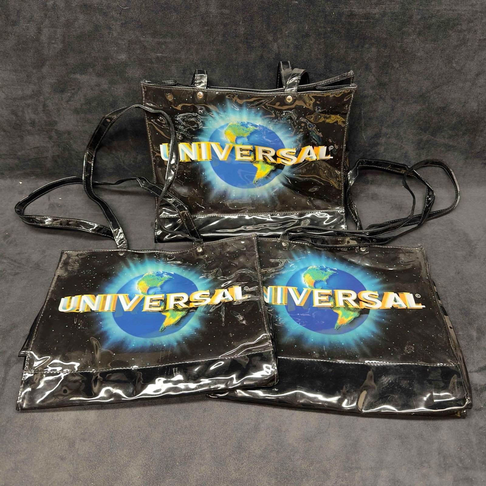 Spencer Gifts Universal Studios Globe Black Tote Bag Set Lot of Three: Spencer Universal Studios Black Tote Bag Set Lot of Three. This lot of three black tote bags were originally offered at Spencer Gifts. These tote bags feature the Universal Studios Globe logo. Black