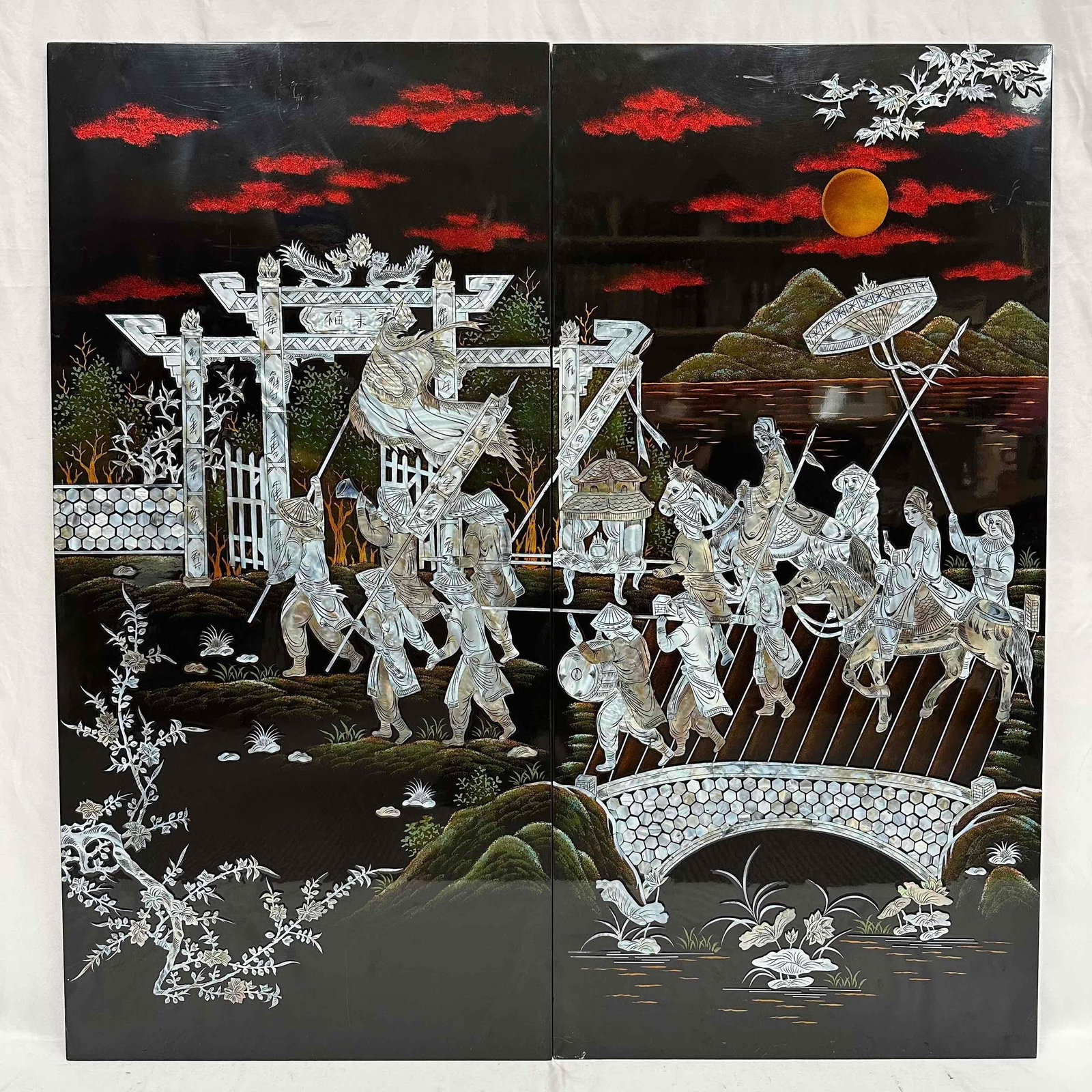 Imperial Procession Under The Crimson Skies Two-Panel Mother of Pearl Inlay Wall Art R92: This striking two-piece wall panel set showcases a detailed imperial procession rendered in exquisite mother of pearl inlay on a lustrous black lacquer background. The scene captures a regal