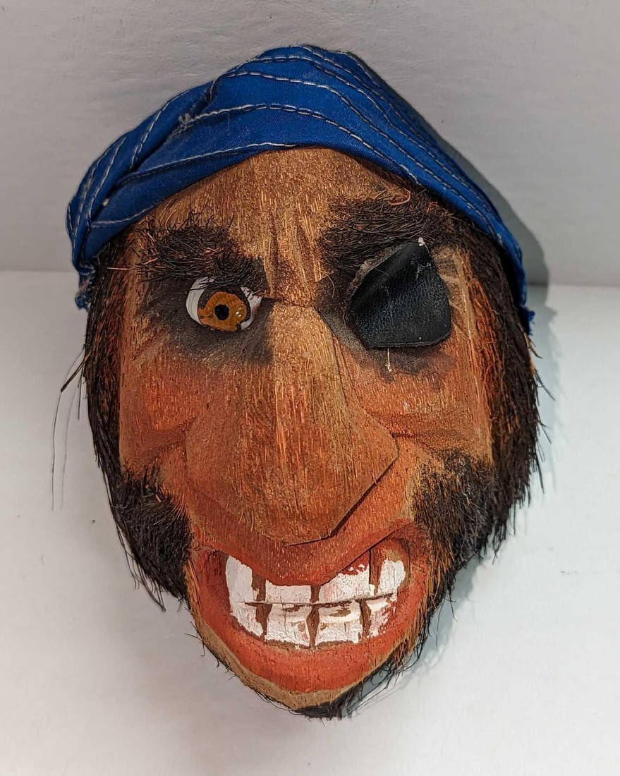 Carved Coconut Pirate Head Wall Art: Carved Coconut Pirate Head Wall Art. This is approx 5" x 5" x 7 1/2" and it weighs 0.47lb. There is a small chip on the eye patch. Has a hold in the back for hanging.