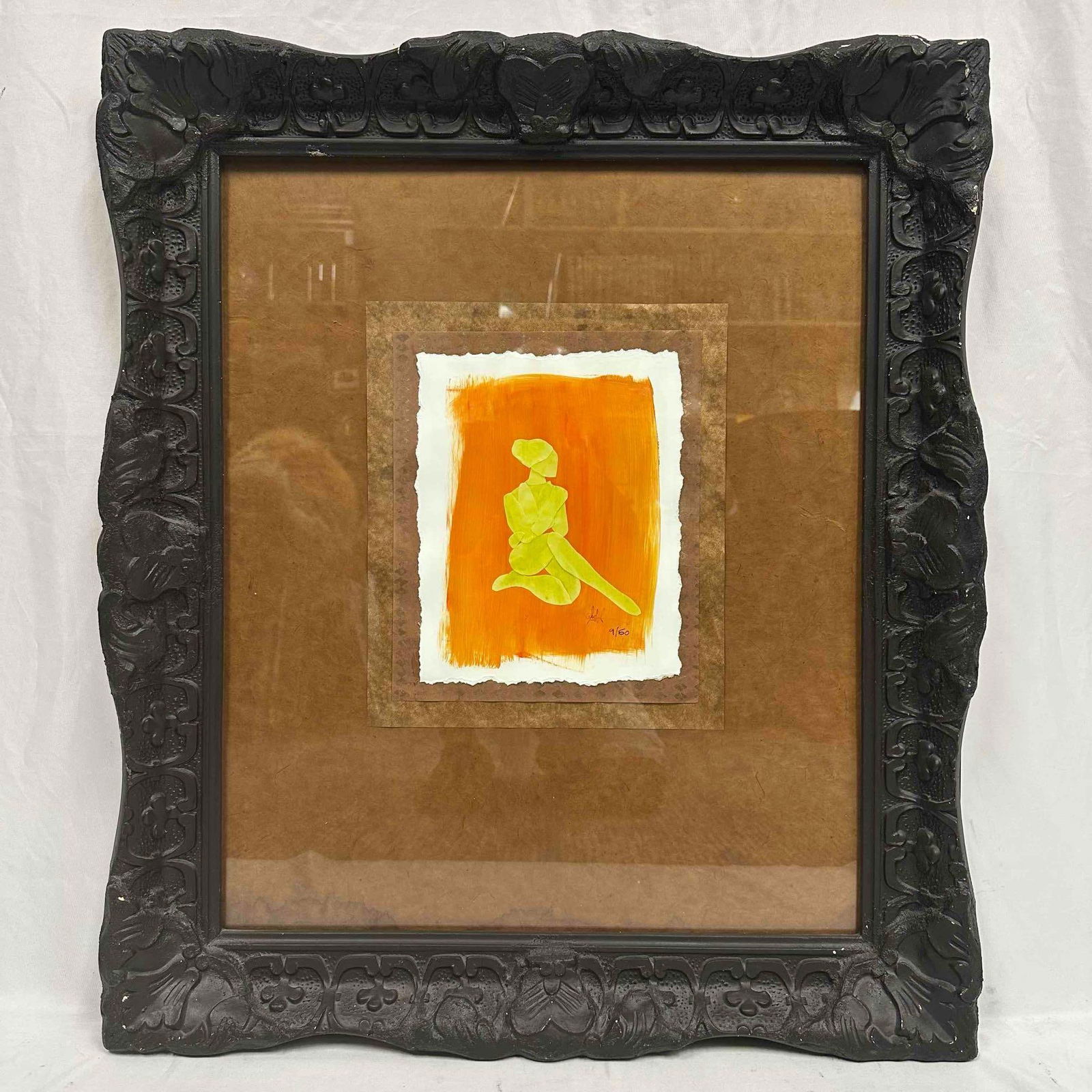 Black Frame Mixed Media Sunlit Repose Minimalist Silhouette Seated Figure Numbered R148: This framed artwork features a minimalist silhouette of a seated figure, rendered in vibrant yellow against a bold orange background. The piece is presented on textured paper with a torn edge, adding