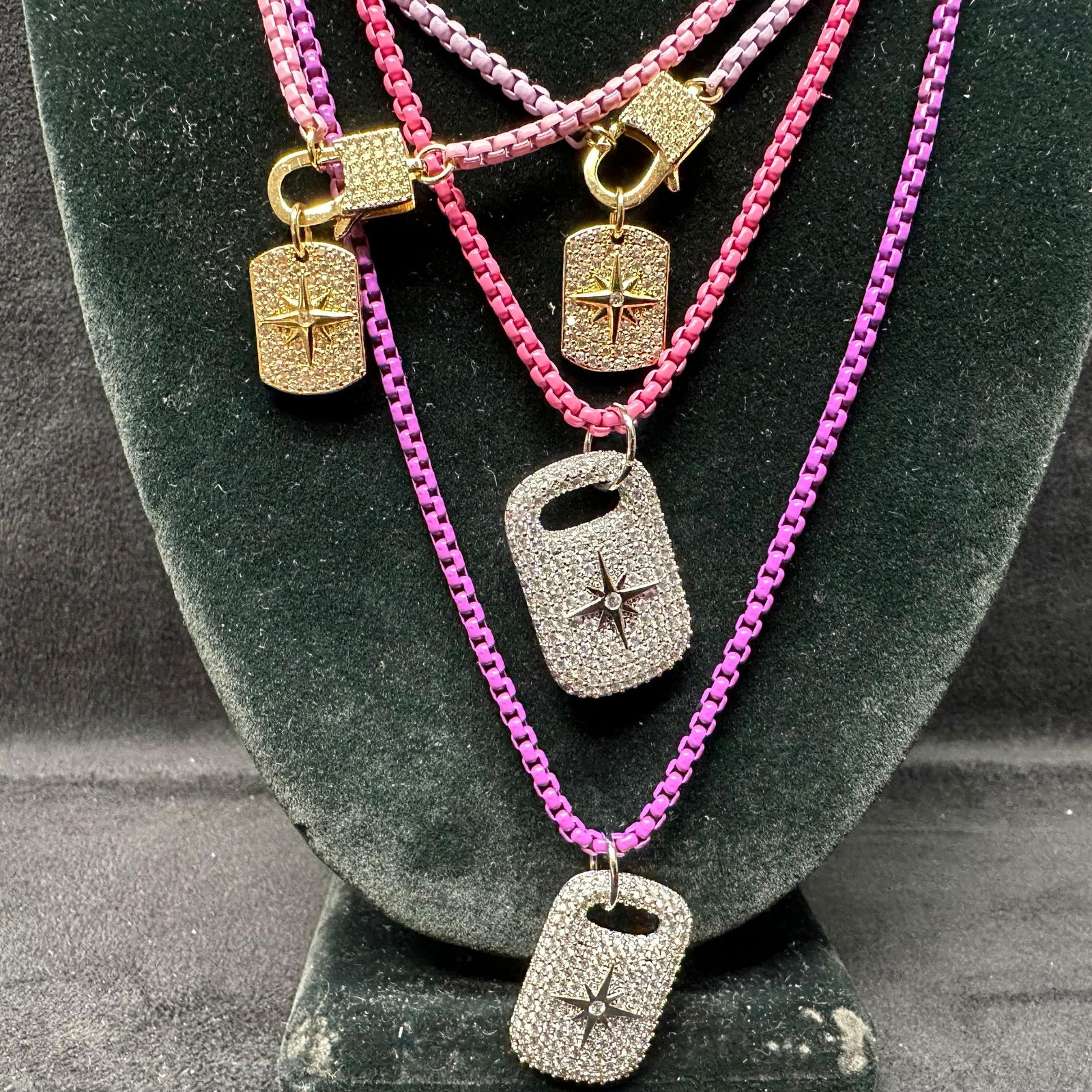 Melania Clara Assorted Purple Pink Necklace Rhinestone Accent Chain Set L96: The Melania Clara necklace set features a magnet clasp closure. The necklaces have magnet extender clasp closures. Each necklace showcases modernist designs with gold-toned and rhinestone accents. The
