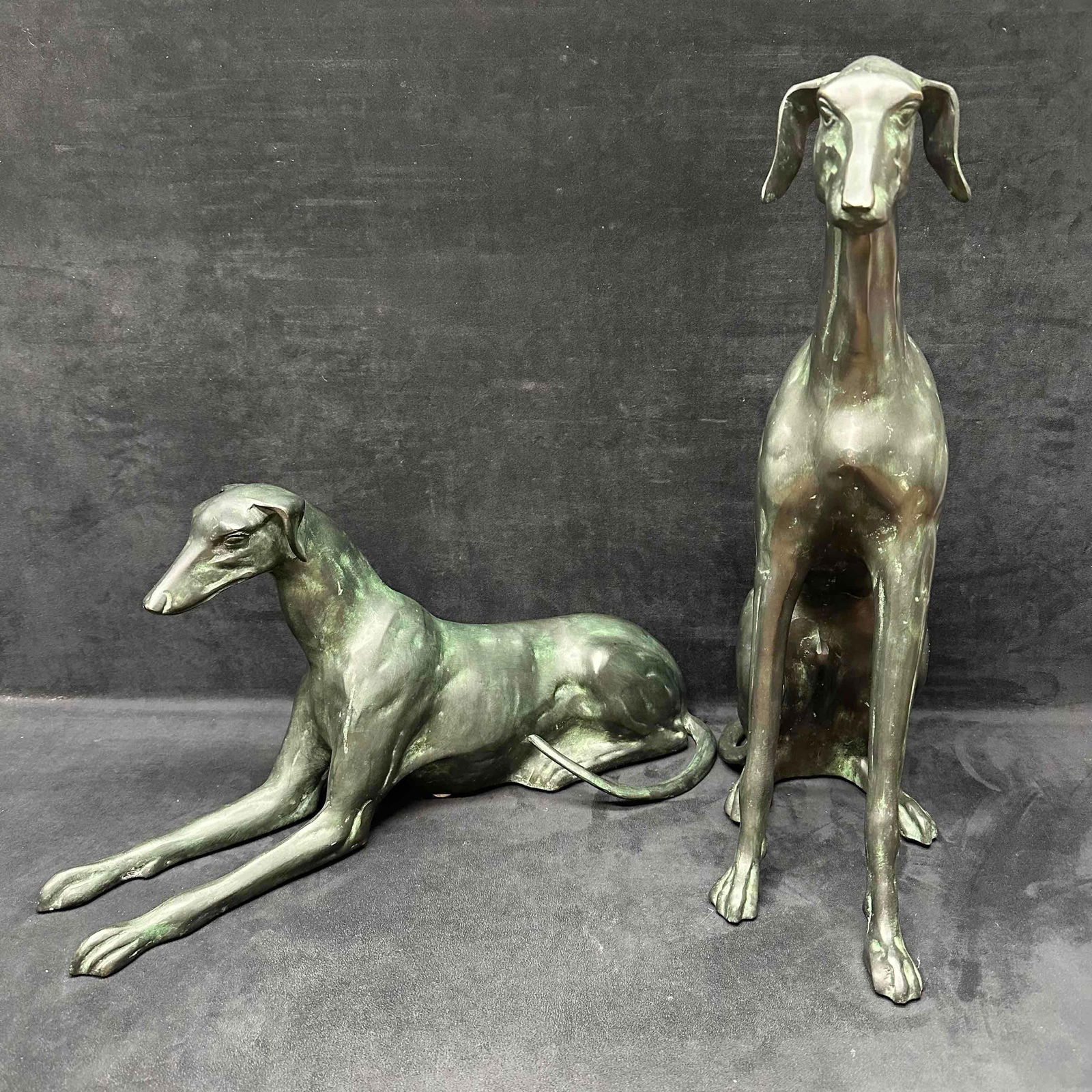 Whippet Greyhound Dog Metal Art Sculpture Statue Set Dogs Sitting Laying Decor Medium Sized: Medium sized Whippet greyhound art sculpture with a dog laying down and one dog sitting. The metal statue set showcase a dark green and black color scheme. Unknown origin, no hallmarks or maker marks.