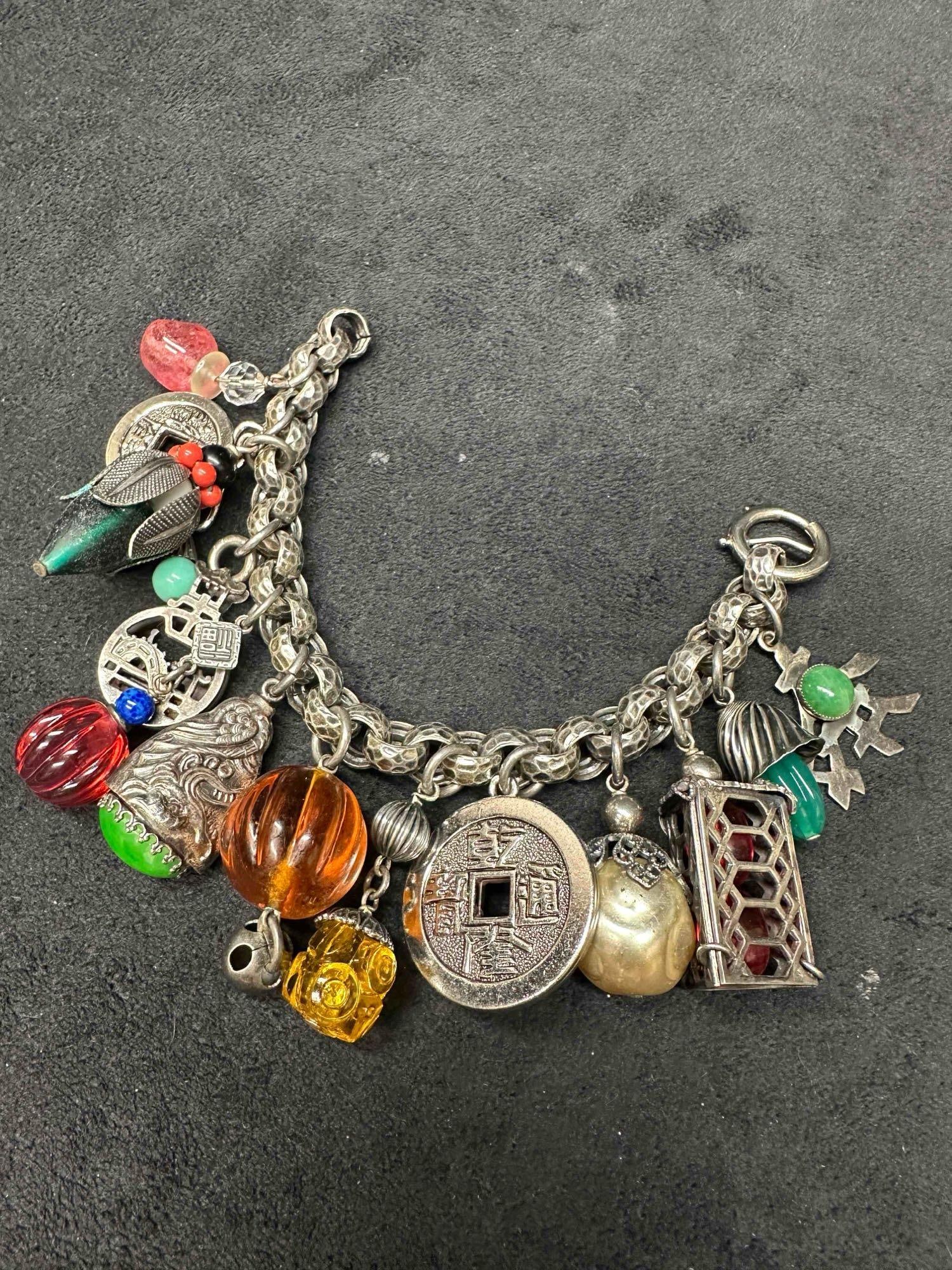 Napier Asian Inspired Metal Glass Art Charm Bracelet: Napier Asian Inspired Metal Glass Art Charm Bracelet Featuring Chunky Charms Made From a Variety of Materials on Silver Tone Link Bracelet. Bracelet measures 7 1/2 inches and charms average about 1