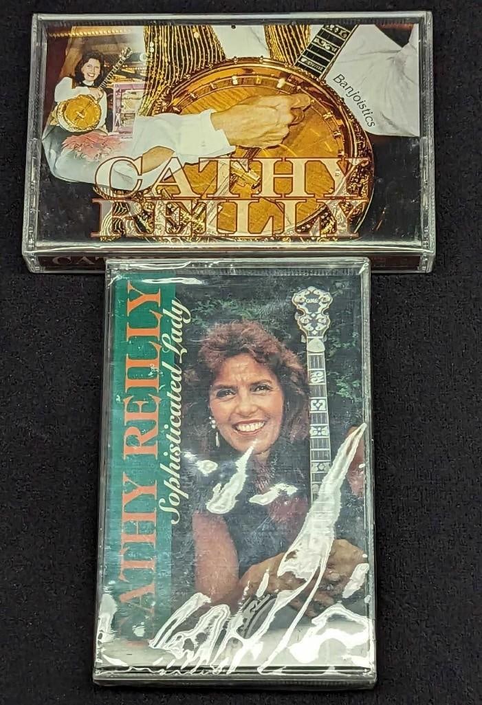 2 Cathy Reilly Sealed Banjo Sealed Cassettes: 2 Cathy Reilly Sealed Banjo Sealed Cassettes. This lot includes; (1) Cathy Reilly - Sophisticated Lady. This was released by Disc Makers in 1994. (1) Cathy Reilly - Banjoistics. This was released by