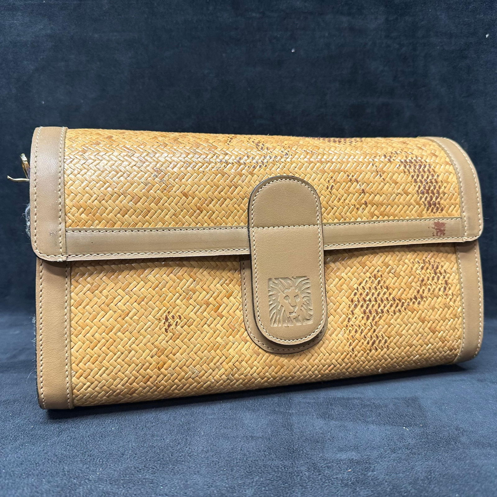 Anne Klein Woven Straw and Leather Shoulder Bag: Woven straw shoulder bag with tan leather trim by Anne Klein. Rectangular structured form with front flap snap closure and decorative embossed leather tab. Rear exterior zip pocket with metal Anne