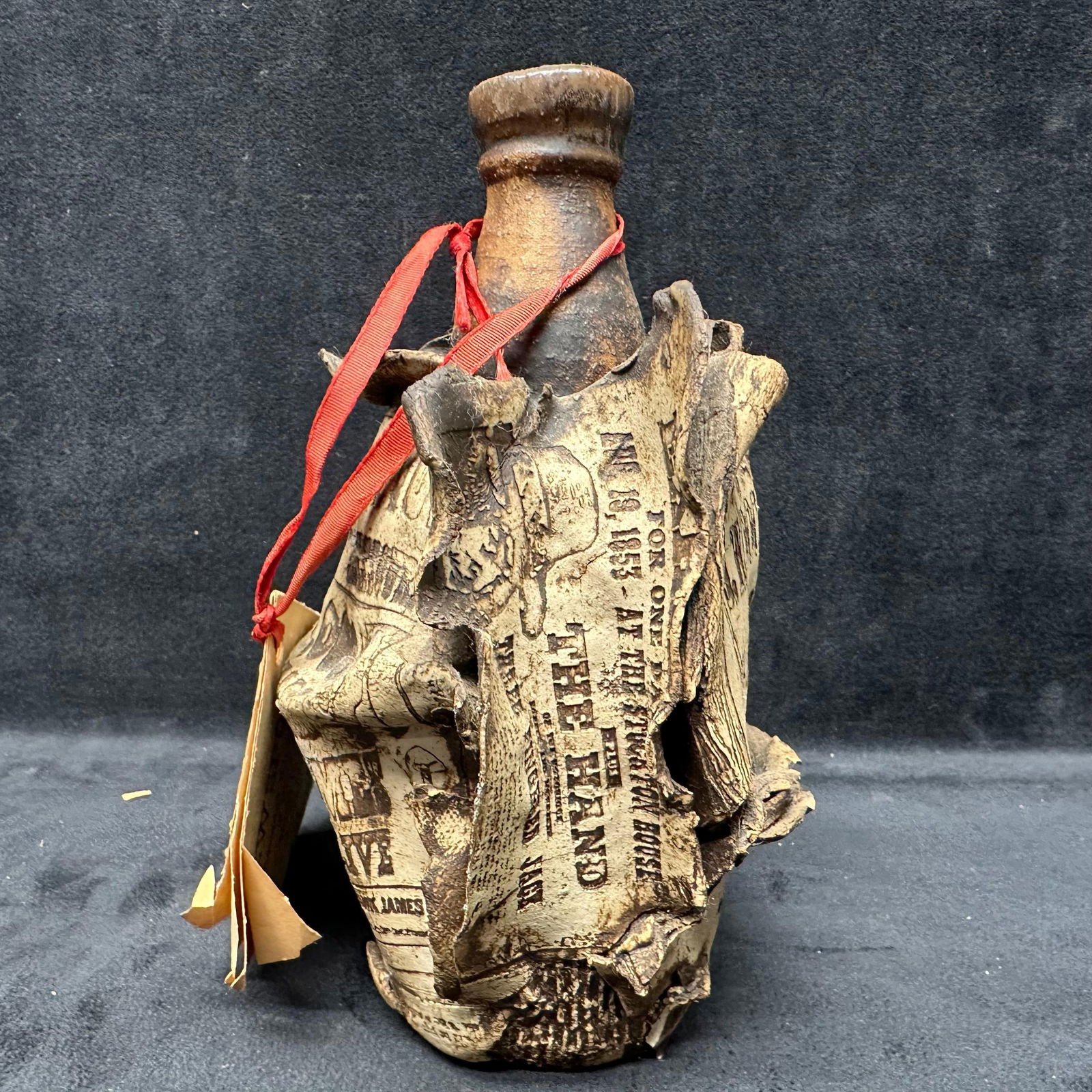 Ron Krogh New Spots High Fire Pottery Jug Jesse James Poster Headlines Inlaid in Clay: Unique, New Spots, ceramic jug sculpture by Ron Krogh, from his High Fire Pottery Lab in North Salt Lake, Utah. This piece features historical newspaper headlines and wanted posters, including