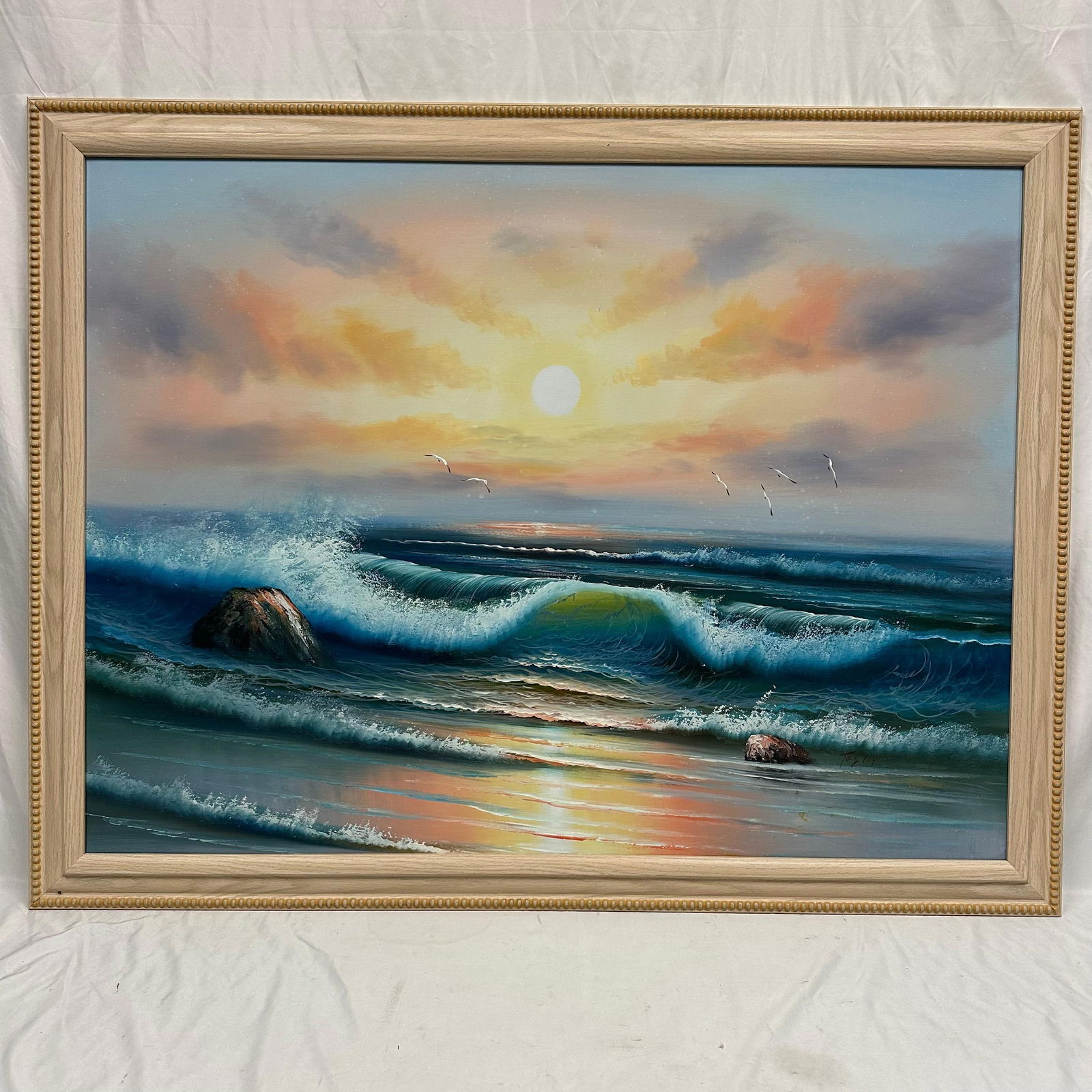 Signed Seascape Oil Painting on Canvas Sunset Ocean Waves with Seagulls: Original oil painting on canvas signed by, unknown artist, depicting a coastal sunset with rolling ocean waves, rocks, and seagulls in flight. Presented in a light wood frame with beaded edge detail.