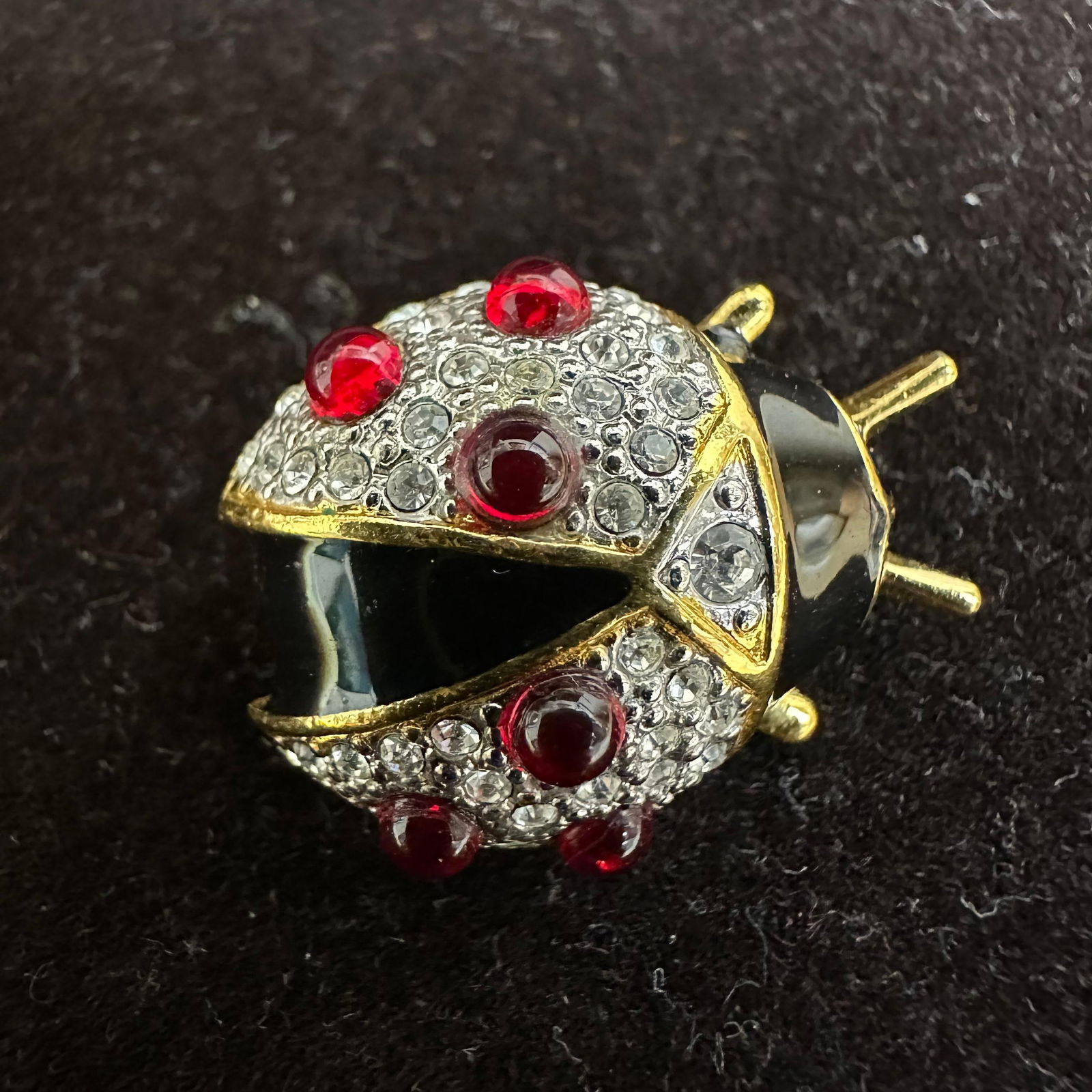 Joan Rivers Gold Tone Ladybug Brooch White Crystals Red Stones Black Enamel Accents: Hallmark Joan Rivers on the back of the gold-toned brooch featuring red, black, and clear rhinestones, stone, and enamel accents. This item is in good pre-owned, previously displayed condition with li