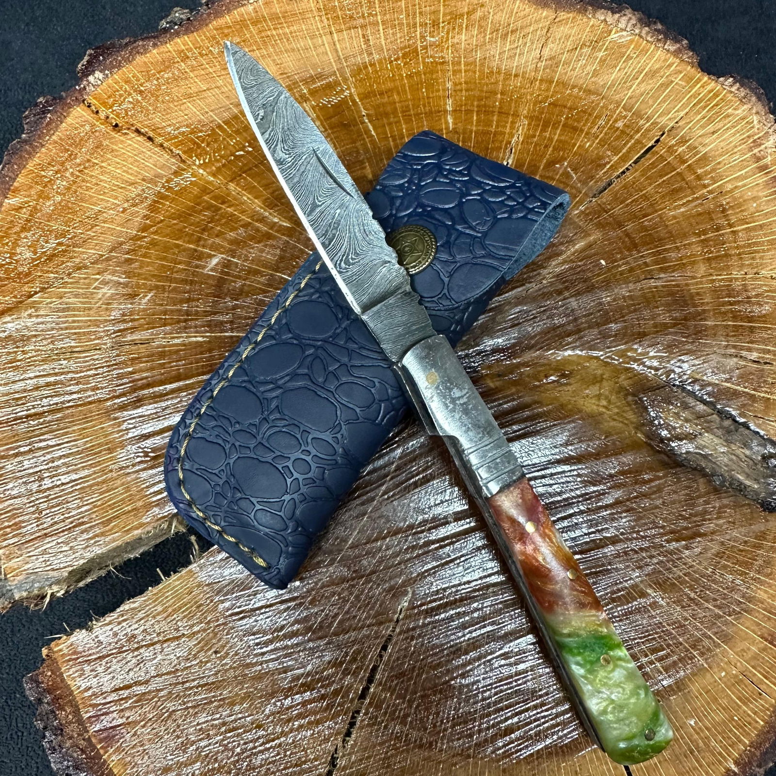 MHS Cutlery Steel Folded Straight Blade Pocket Knife Orange Green Handle Q85: Folding blade pocket knife by MHS Cutlery featuring a layered patterned steel straight blade and decorative spine work. The handle has a contoured, multi-color wood/resin-style grip with metal mosaic