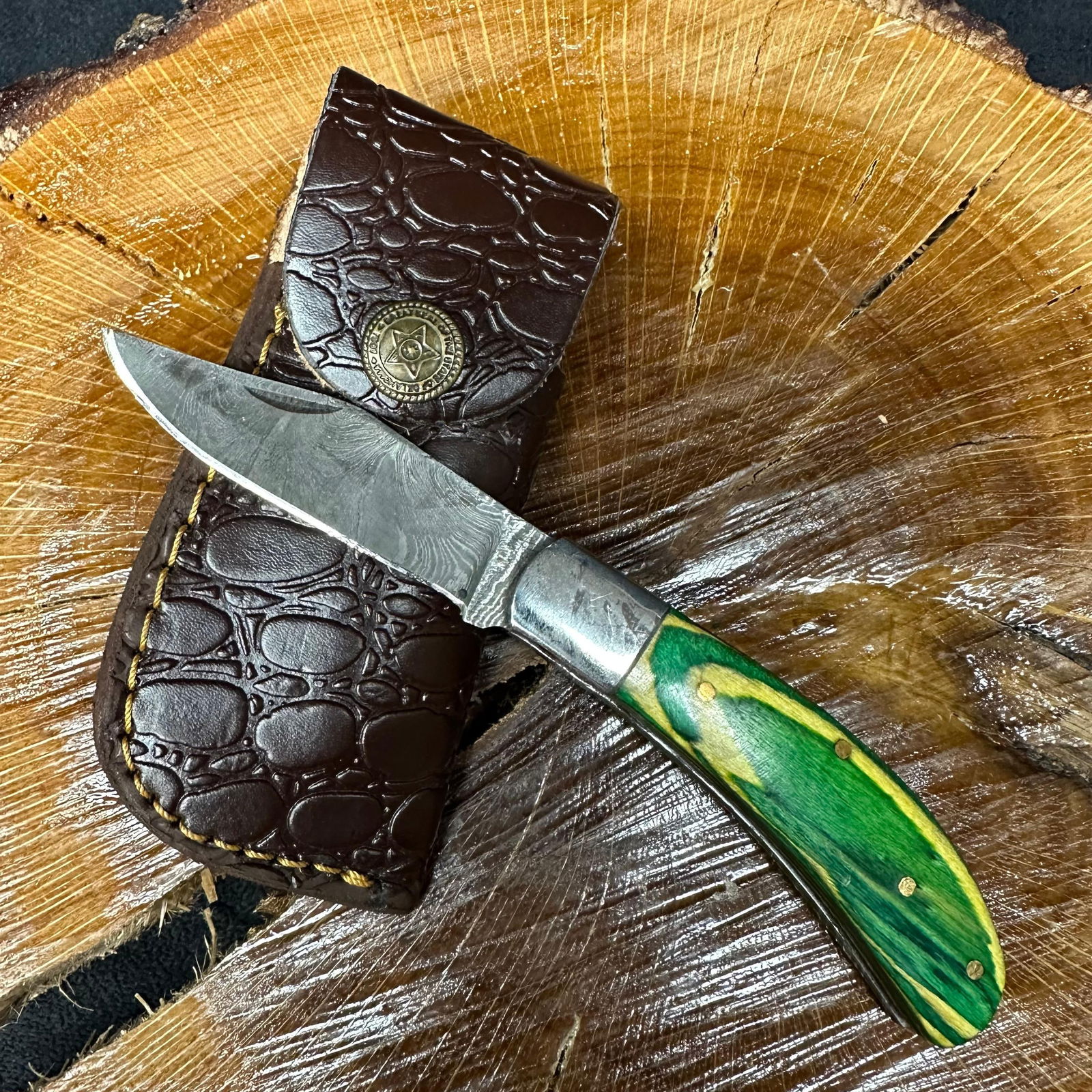 MHS Cutlery Steel Folded Blade Pocket Knife Yellow Green Handle Q86: Folding blade pocket knife by MHS Cutlery featuring a layered patterned steel blade and decorative spine work. The handle has a contoured, yellow/green wood/resin-style grip with metal mosaic pin