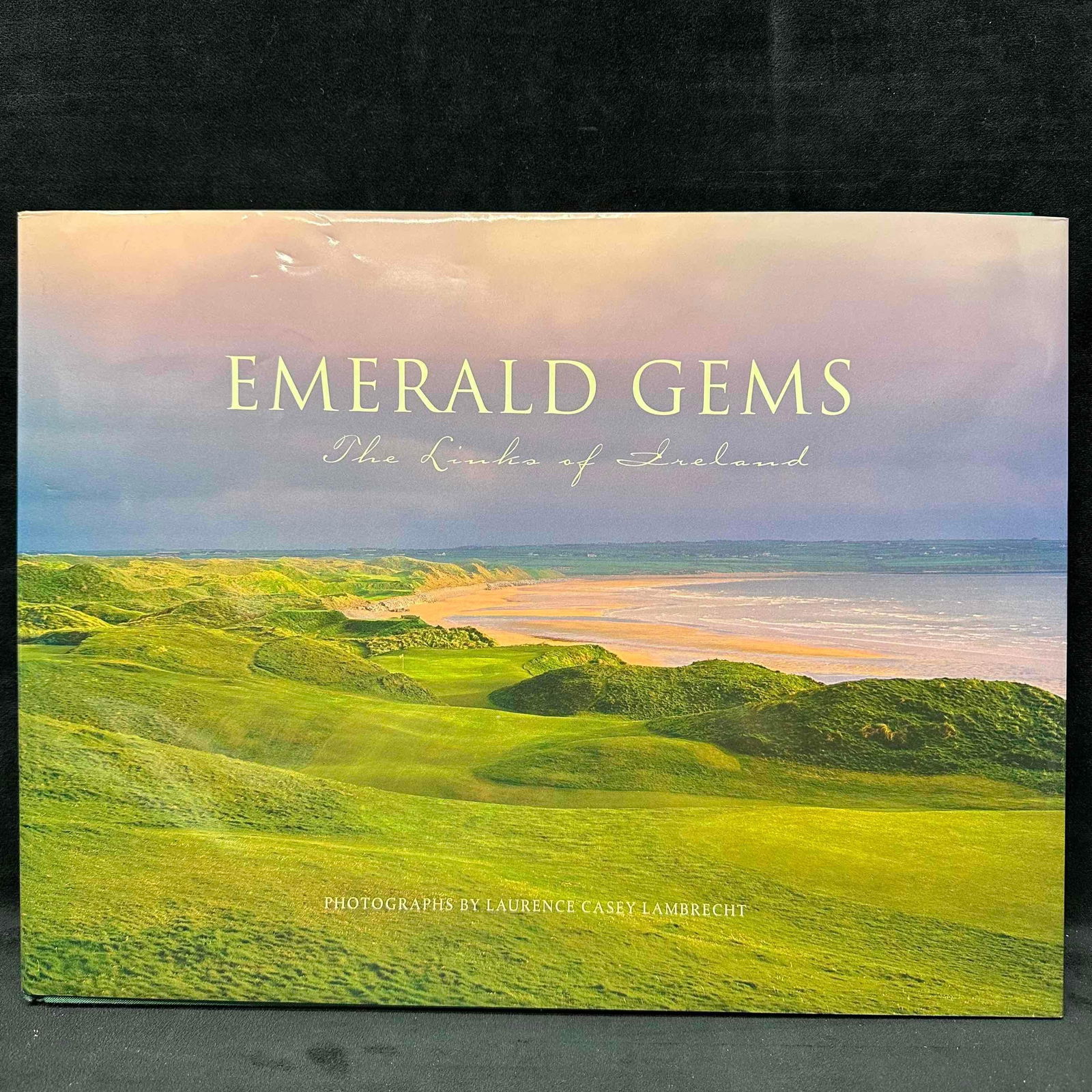 Emerald Gems The Links of Ireland Laurence Casey Lambrecht Golf Photography Hardbound Book: Beautiful large-format photography book Emerald Gems: The Links of Ireland with photographs by acclaimed golf photographer Laurence Casey Lambrecht. This coffee table book captures Ireland’s legenda