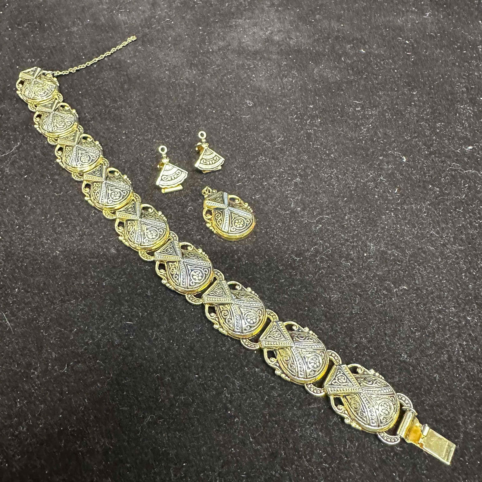 Gold Silver Tone Black Enamel Bracelet with Matching Pendant and Earrings Set J16: Ornate vintage jewelry set featuring a wide link bracelet with safety chain, matching pendant, and clip-on earrings. Gold and silver tone with detailed black enamel engraved designs. Safety chain is b