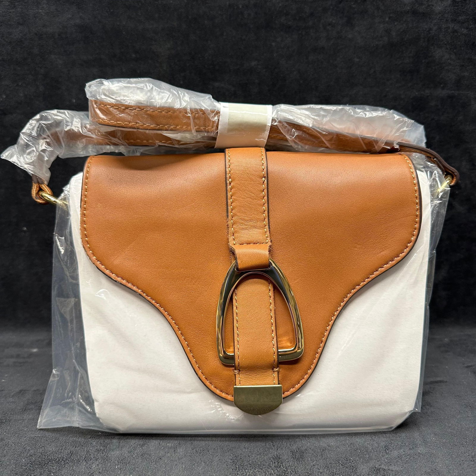 GILI Got It Love It Tan Orange and Cream Colored Canvas Crossbody Bag: This is a G.I.L.I. orange/cream canvas and leather small crossbody bag with a stirrup buckle. This item is in like-new, previously displayed condition with light wear and surface markings. Please