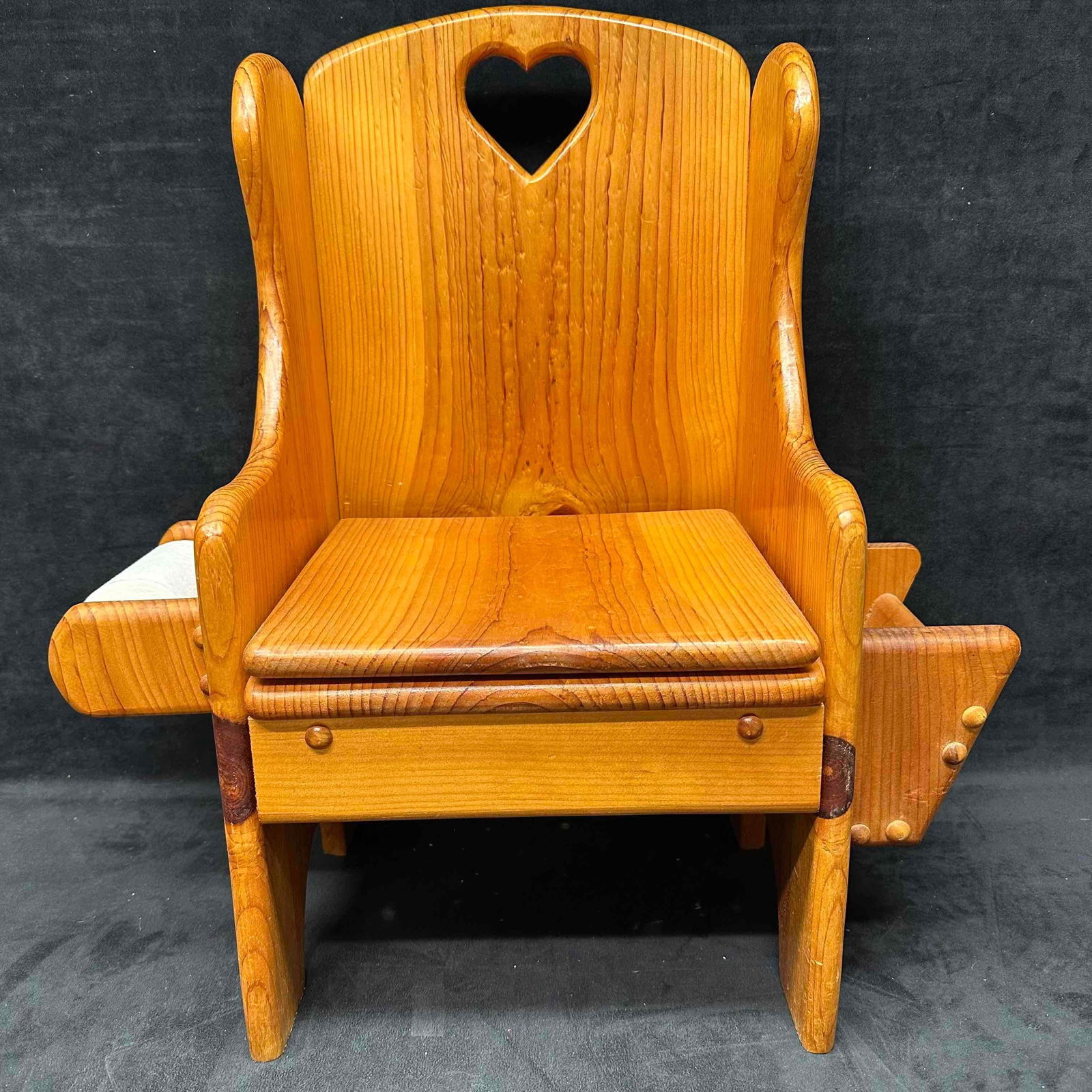 Wooden Child’s Potty Chair with Heart Cutout and Removable Plastic Chamber: Vintage wooden child’s potty chair, featuring a heart cutout on the backrest and winged sides. The seat lifts to reveal a built-in potty with a removable white plastic chamber pot for easy cleaning.