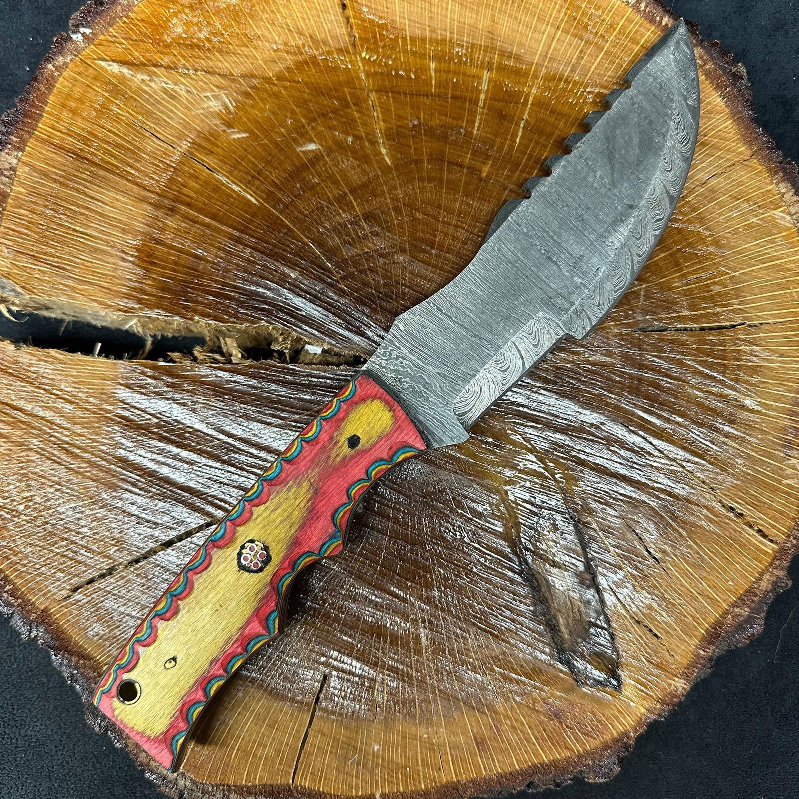 MHS Cutlery Steel Fixed Blade Hunting Knife Wood Epoxy Resin Style Handle: Fixed blade hunting knife by MHS Cutlery featuring a textured steel blade. The handle features a contoured, multi-colored wood/epoxy resin-style grip with metal mosaic pin accents. Includes a fitted b