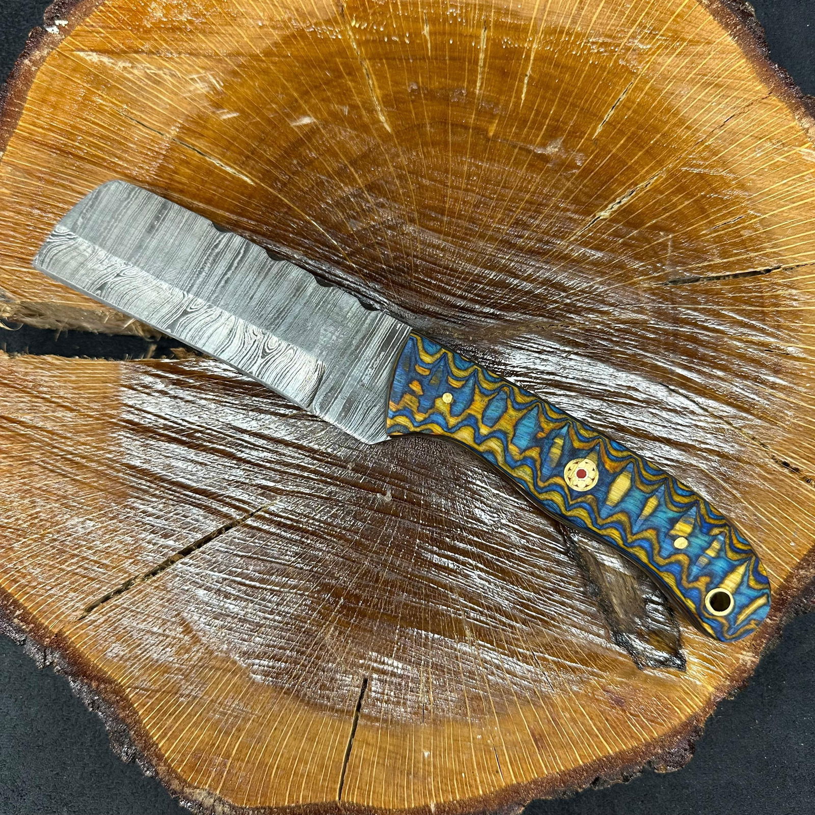 Blue Tan Colorway Design Handle MHS Cutlery Fixed Blade Knife P84 Cleaver Style: Fixed small, cleaver-style blade knife by MHS Cutlery featuring a layered patterned steel blade and decorative spine work. The handle features a contoured, wood/epoxy resin-style grip with metal mosai