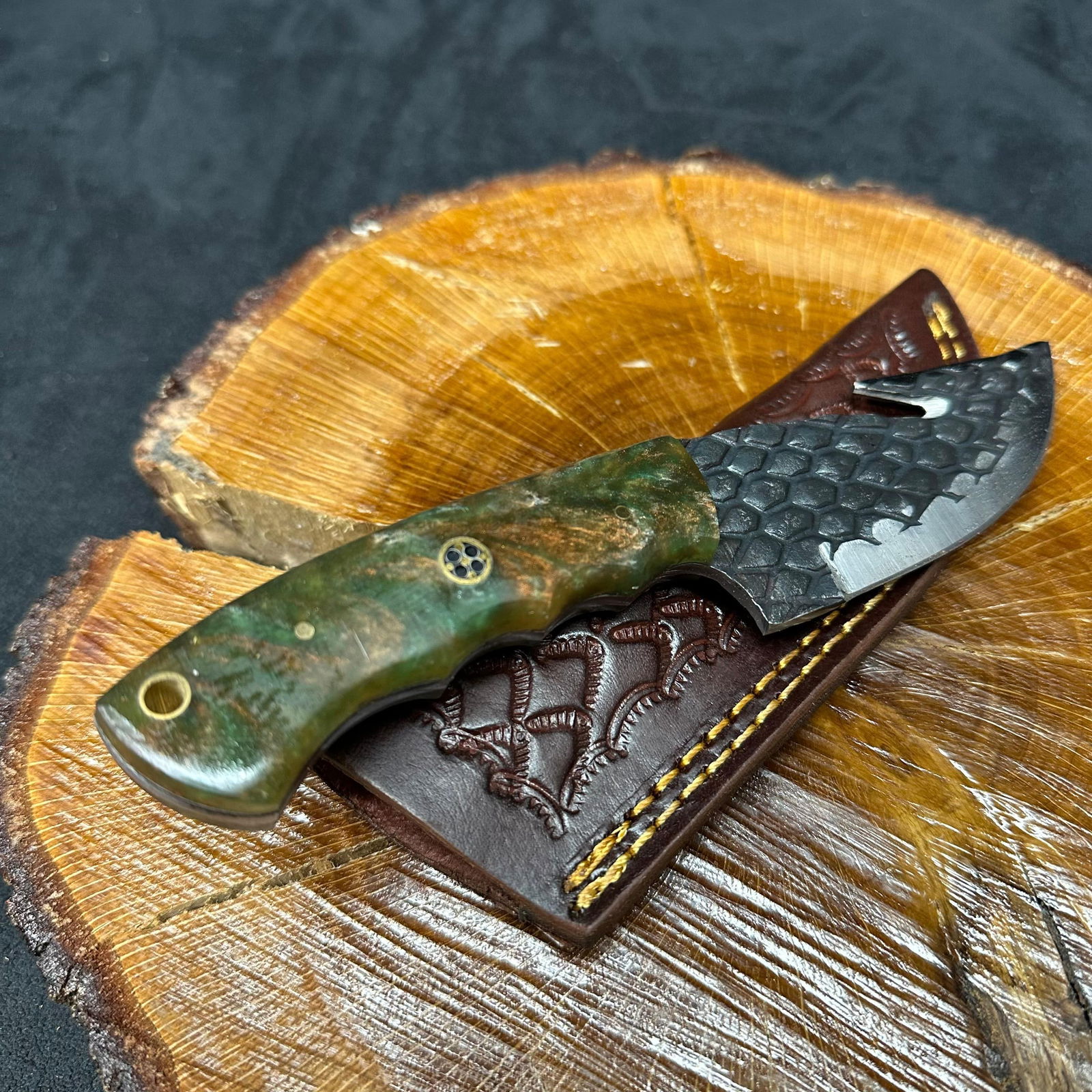 MHS Cutlery Fixed Textured Blade Knife Q3 Hunting Style: Fixed blade knife by MHS Cutlery featuring a textured steel blade and decorative spine work. The handle has a contoured, multi-colored wood/epoxy resin-style grip with metal mosaic pin accents. Includ