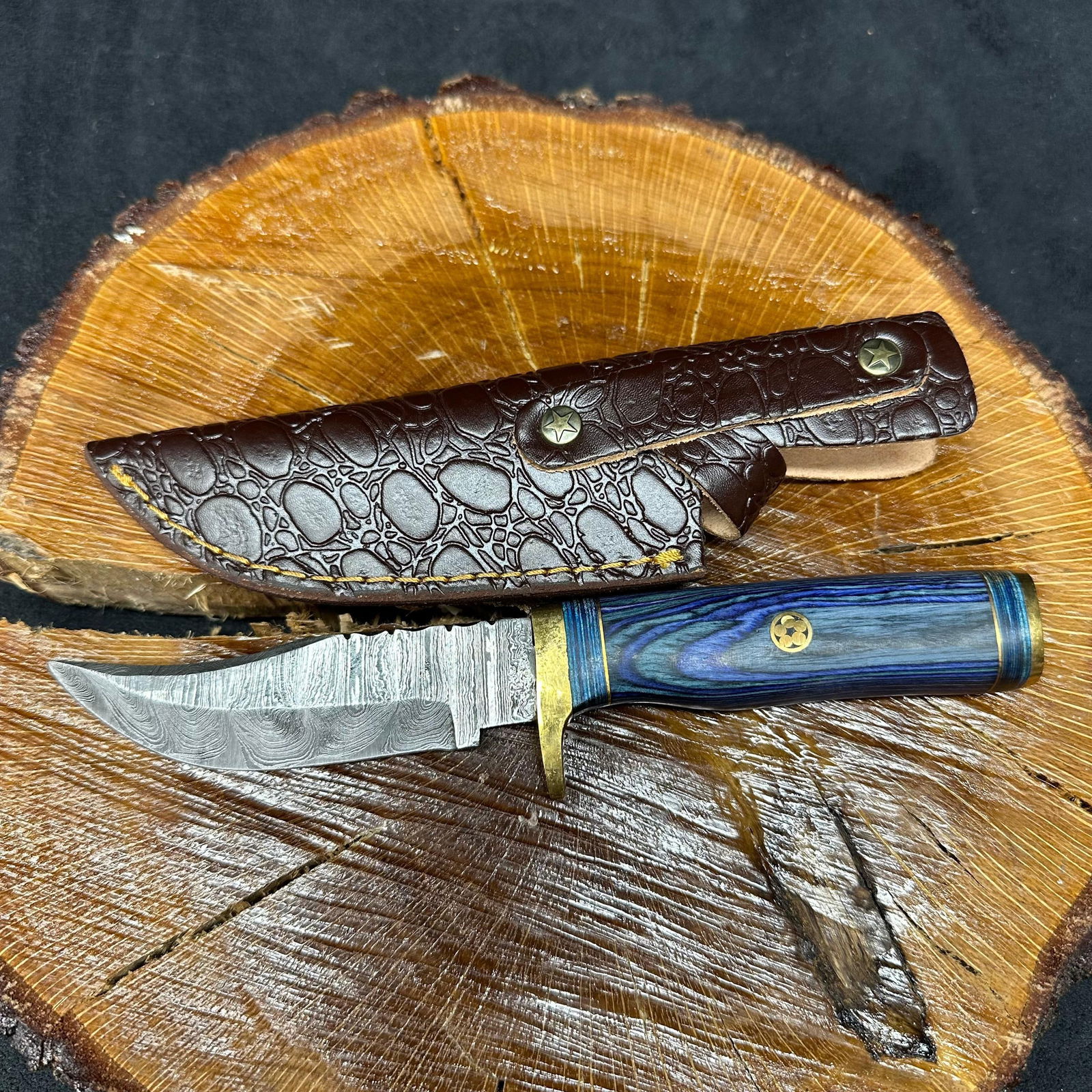 MHS Cutlery Fixed Blade Knife Q3 Hunting Style Brass Guard Handle: Fixed blade knife by MHS Cutlery featuring a steel blade and decorative spine work. The handle has a contoured, multi-colored wood/epoxy resin-style grip with metal mosaic pin accents. Includes a fitt