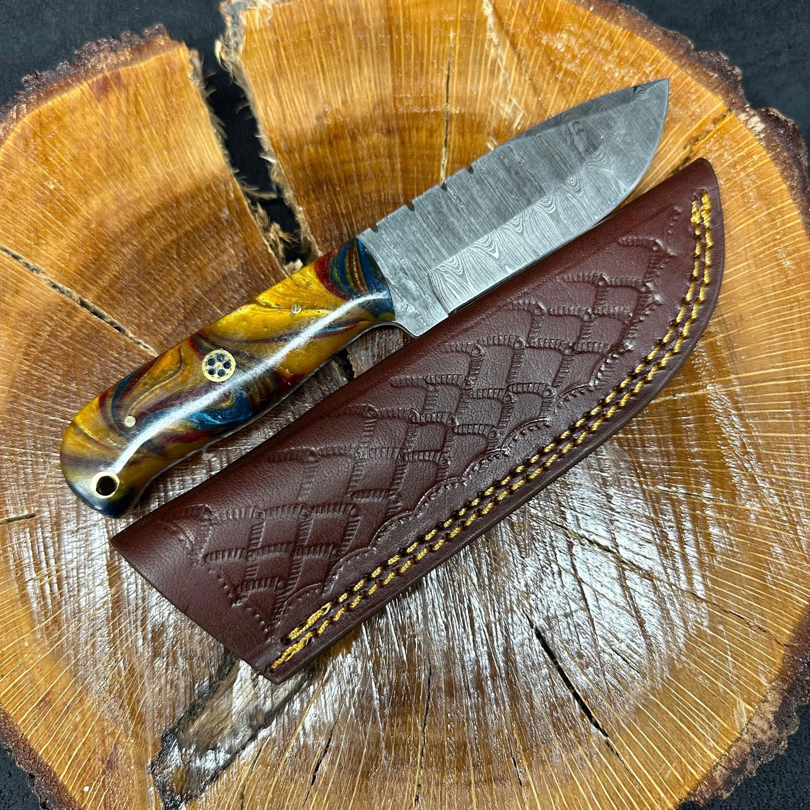 MHS Cutlery Fixed Blade Knife Q16 with Leather Sheath: Fixed blade knife by MHS Cutlery featuring a layered patterned steel blade and decorative spine work. The handle has a contoured, dark multi-colored wood/epoxy resin-style grip with metal mosaic pin a