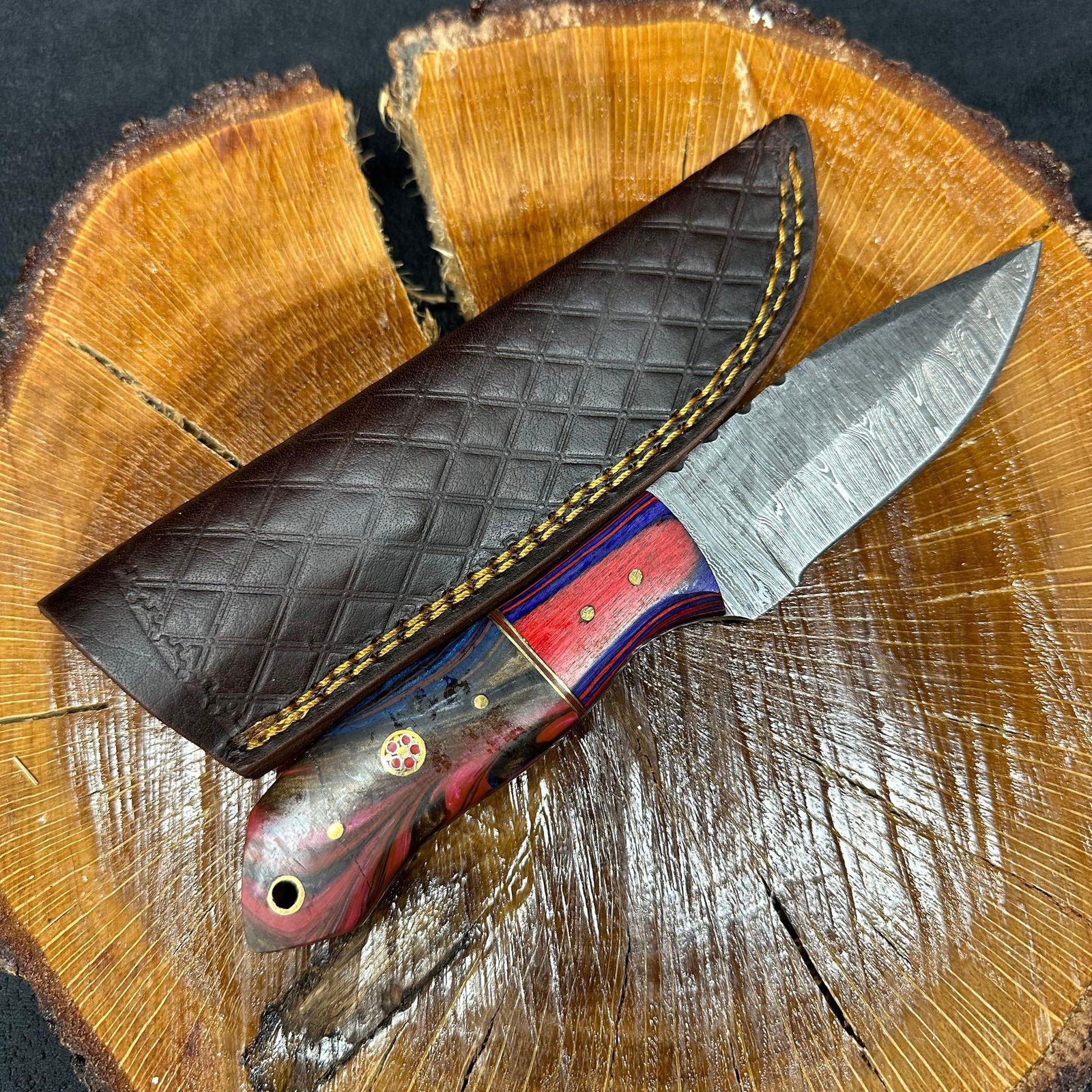 Two Colorway Designs MHS Cutlery Fixed Blade Knife Q17: Fixed blade knife by MHS Cutlery featuring a layered patterned steel blade and decorative spine work. The handle has a contoured, dark multi-colored wood/epoxy resin-style grip with metal mosaic pin a