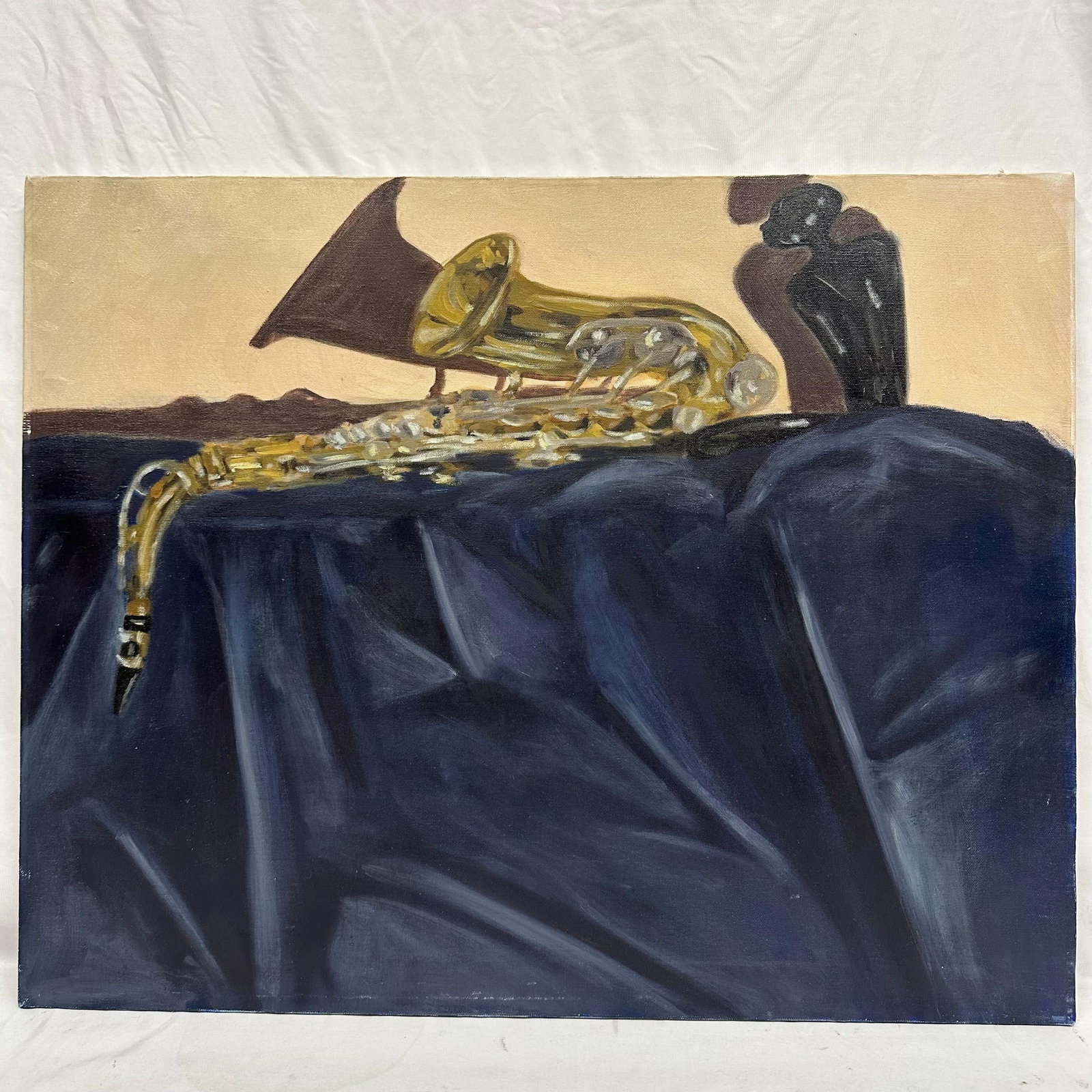 Original Oil Painting Still Life With Saxophone Attributed to Alonzo Adams: Oil on canvas still-life depicting a saxophone resting on draped dark blue fabric with two dark sculptural vessels in the background. Warm neutral tones create contrast against the metallic