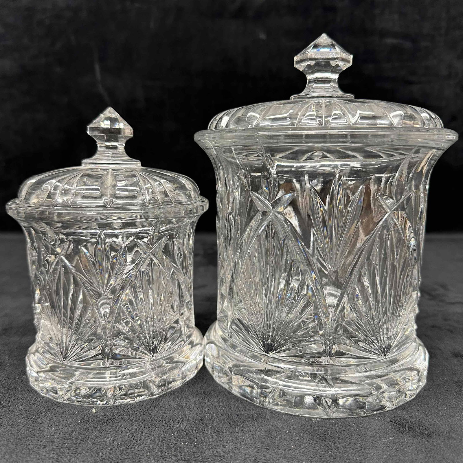 Lead Crystal Glass Lidded Canister Barrel Biscuit Candy Nut Storage Set: This two-piece lidded canister set showcasing brilliance and craftsmanship. Featuring intricate deep cuts in a classic starburst and vertical pattern, each canister is topped with a faceted finial