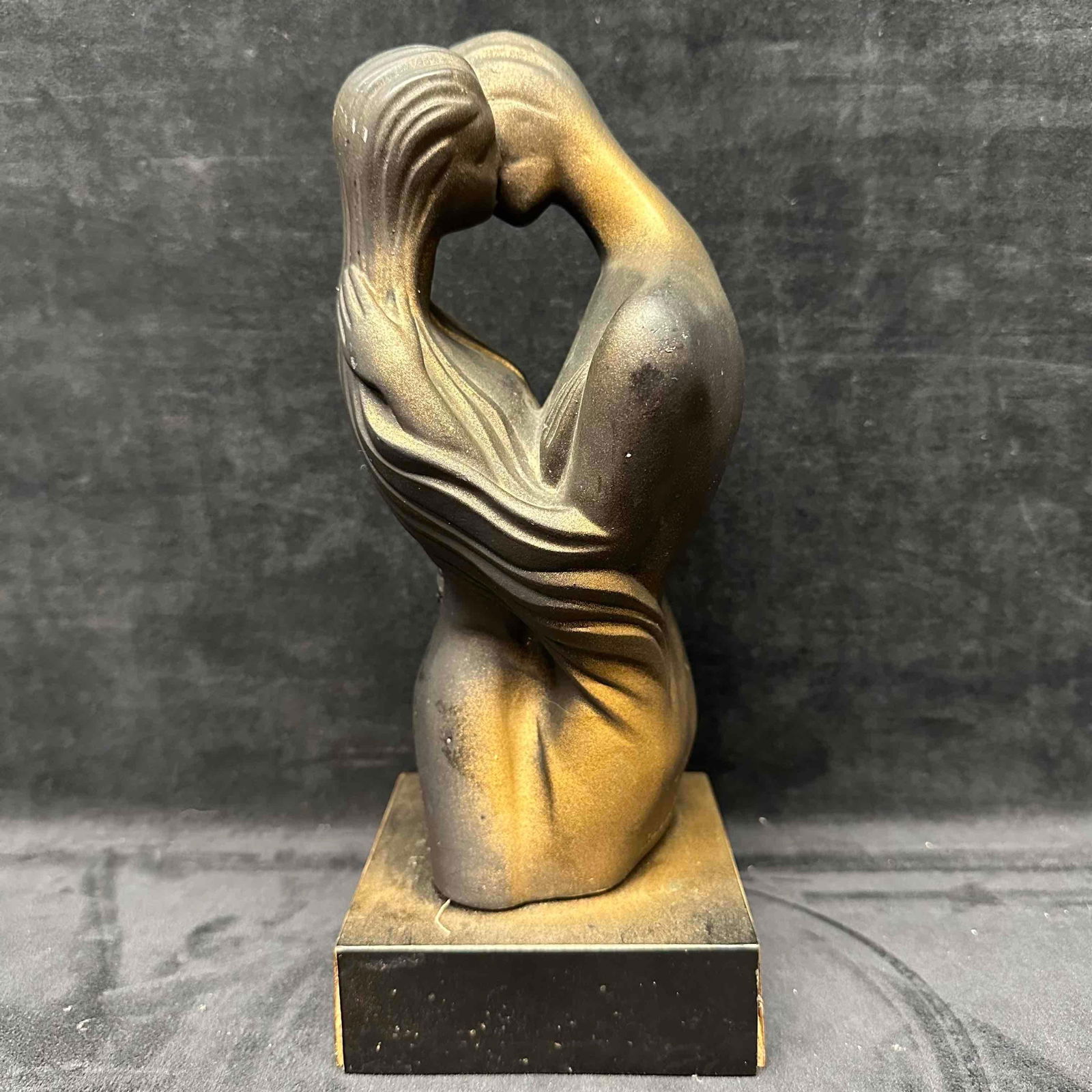 Embrace The Lovers Sculpture by Boris Modernist Abstract Embrace: Sculpture by artist Boris depicting an abstract couple locked in a tender embrace. The piece features smooth flowing lines and a modernist design, finished in matte black with soft gold patina