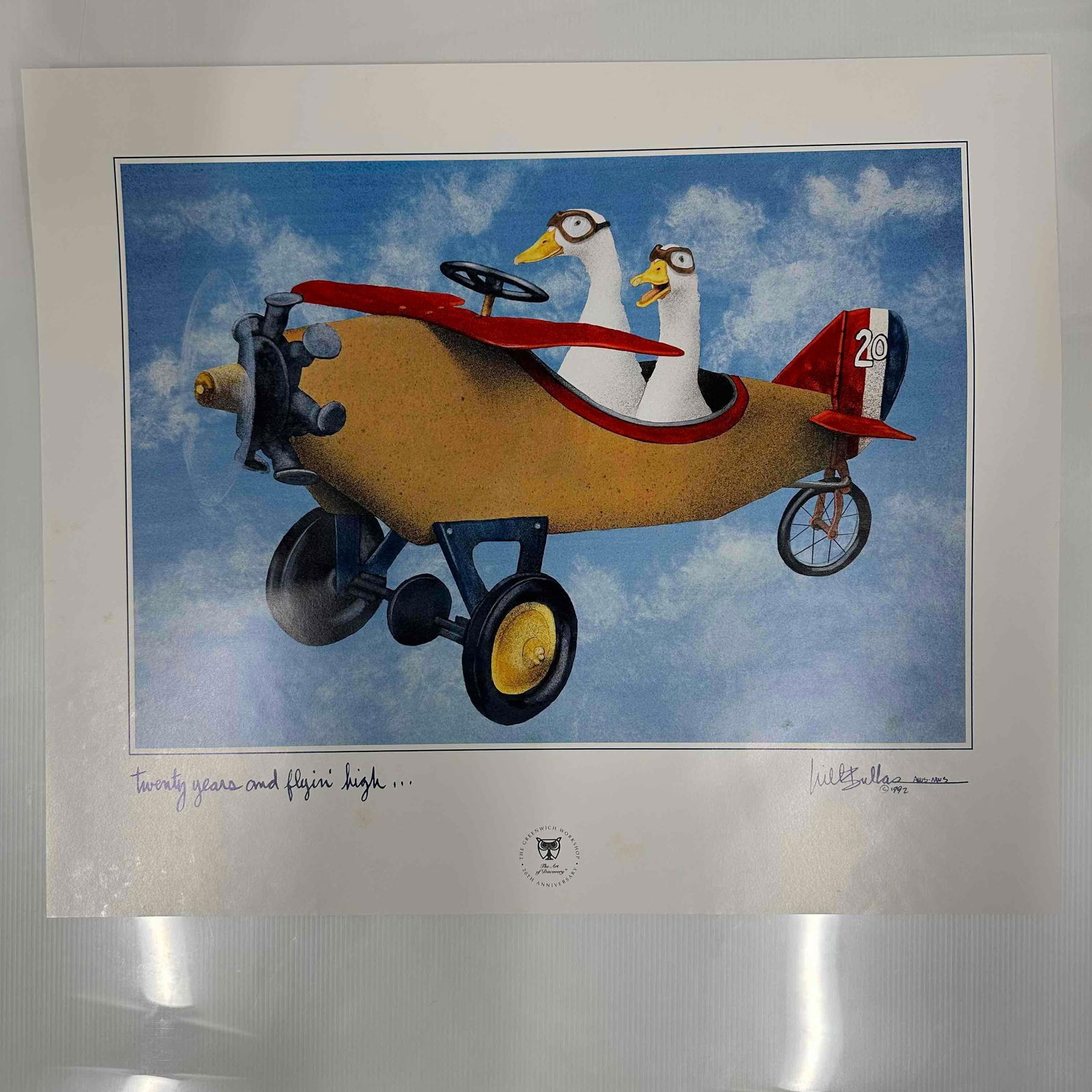 1992 Will Bullas Signed Limited Edition Print Twenty Years and Flyin’ High Greenwich Workshop: 1992 limited edition print by renowned artist Will Bullas, titled “Twenty Years and Flyin’ High”. Features two ducks flying in a whimsical airplane against a bright sky, celebrating the 20th