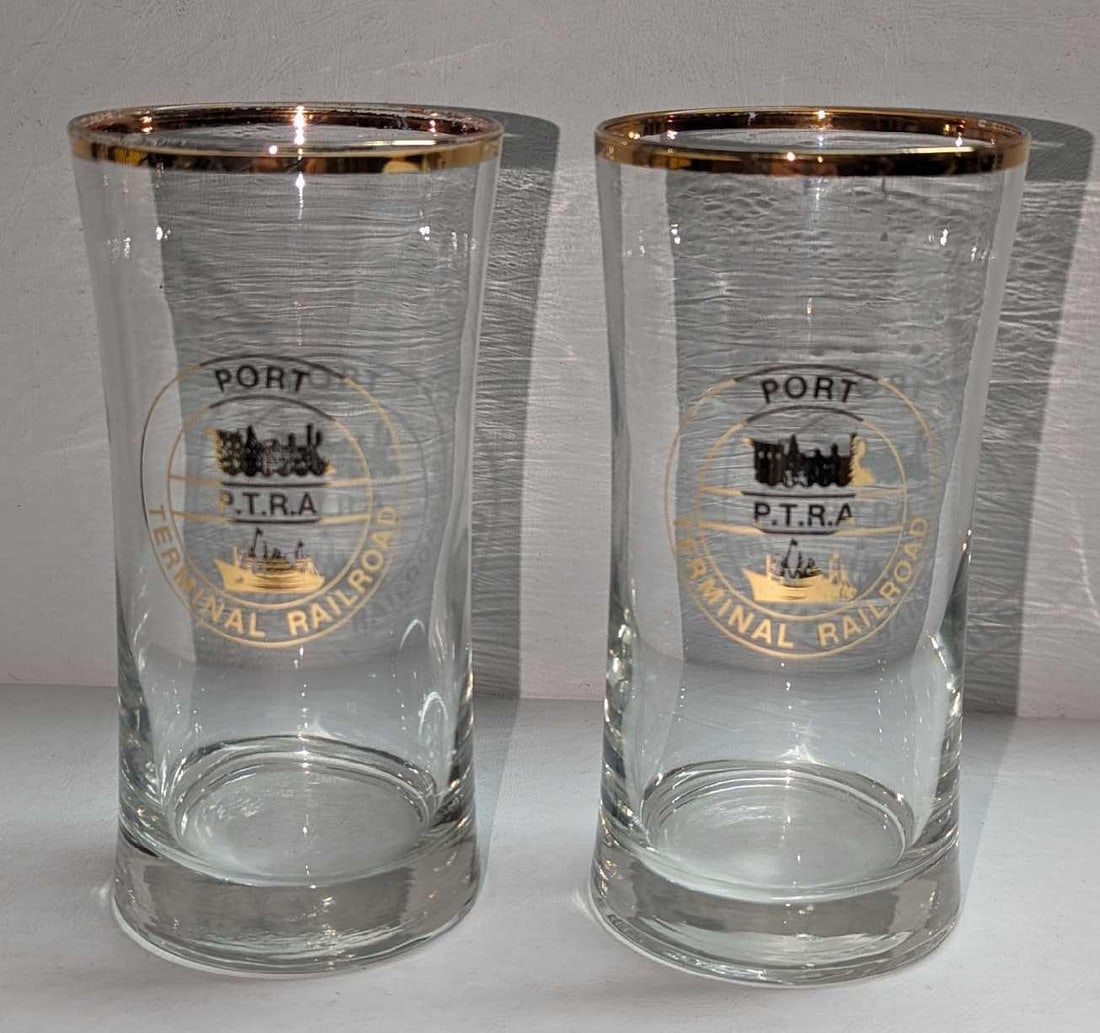 2 Vintage Port Terminal Railroad Gold Rim Glasses: 2 Vintage Port Terminal Railroad Gold Rim Glasses. Each glass is approx 2 7/8" x 2 7/8" x 5 3/4" and the total weight is 1.32lb. There are some scratches on the gold rim. 