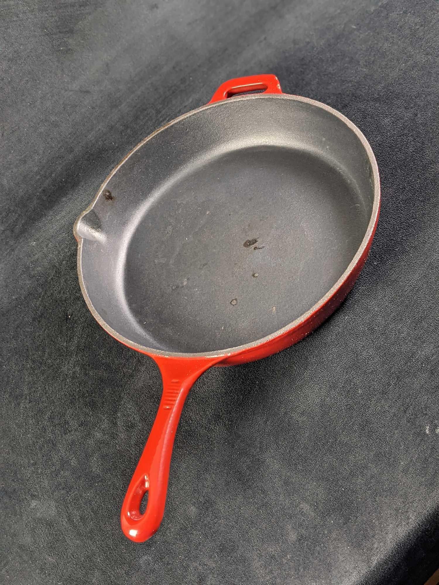 Red Enameled 12" Cast Iron Skillet: Red Enameled 12" Cast Iron Skillet. Company is unknown. Is marked DENMARK and CHINA. Is approx 19" x 12" x 2 1/4" and weighs 8lbs. Is in a good, used condition with some burn markings on the bottom an