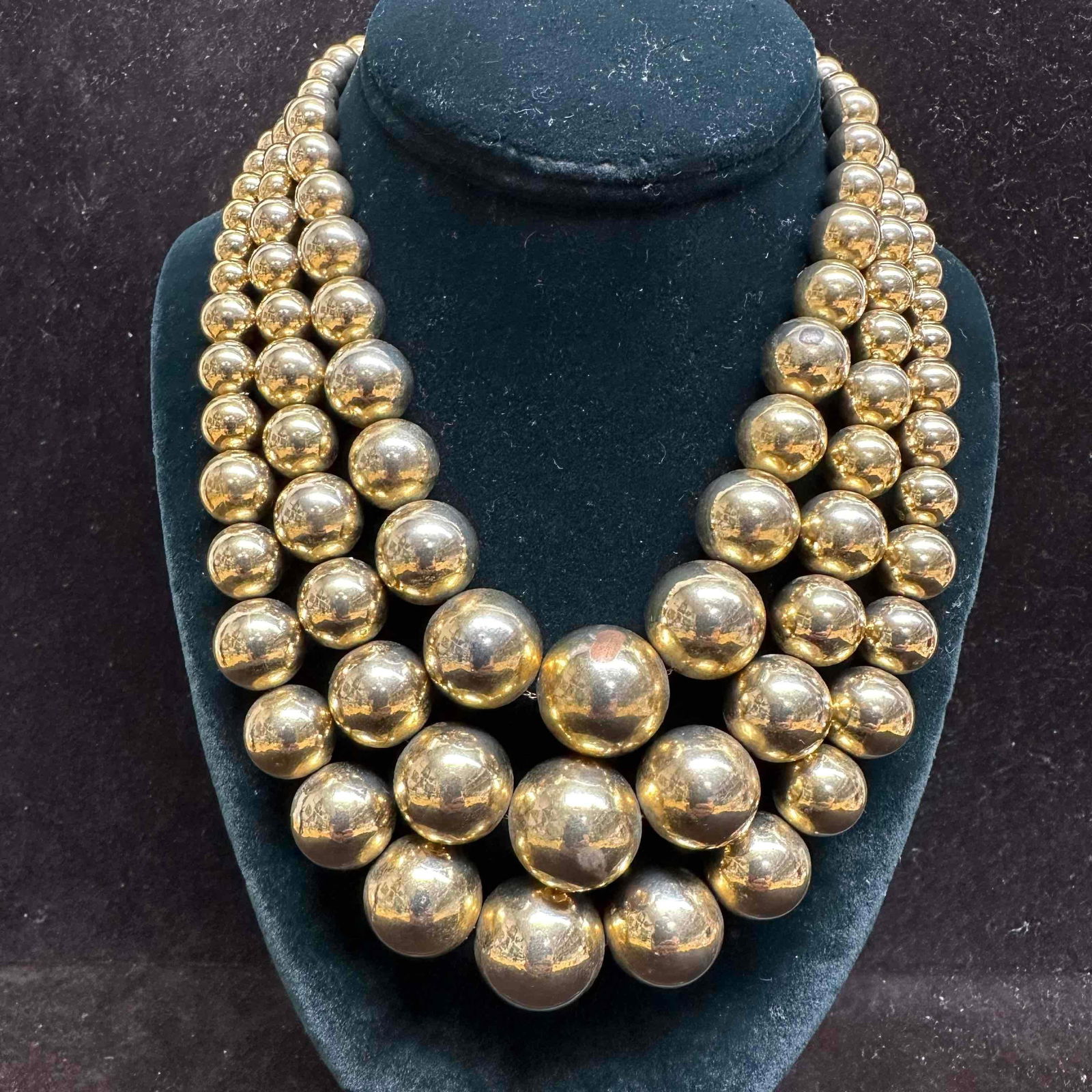 Graduated Beaded Style Gold Toned Coro Necklace: Triple strand graduated beaded gold toned necklace. Marked Coro on j-hook clasp closure. This item is in good pre-owned, previously displayed condition with light wear, and surface scratches. Please r