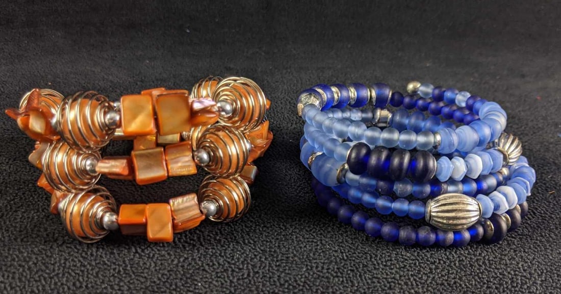 A Pair of Wrap Beaded Bracelets: A Pair of Wrap Beaded Bracelets This pair of bracelets are wire wrap bracelets that have beautiful beads on them. The blue bracelet has frosted glass beads the other bracelet is made from orange paint
