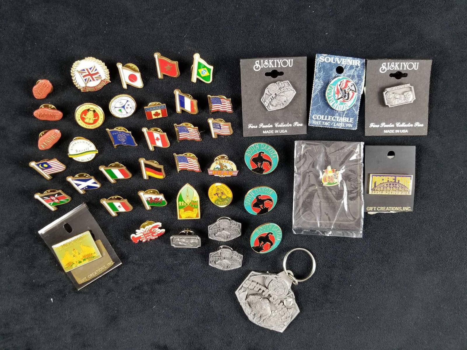Lot Of 42 State And Country Flag Pins And Keychain: This lot includes: Four American pins, one German pin, one French flag pin, one Italian Flag pin, one Japanese flag pins, two Canadian flag pins, one flag of Malay pin, one Welsh flag pin, one fl