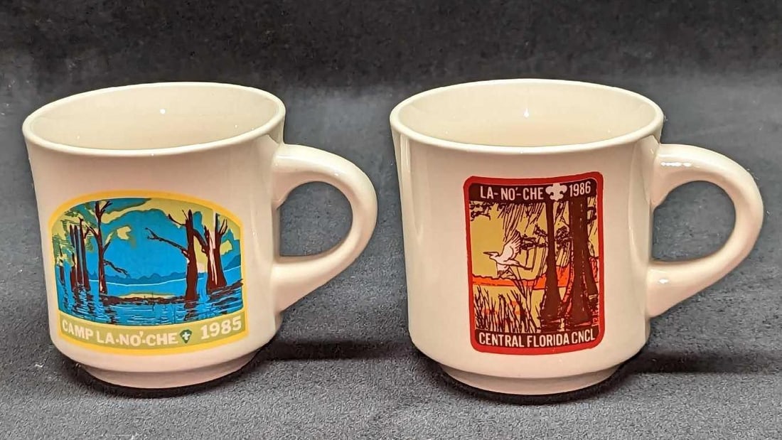 2 Vintage Boy Scout Camp La-No-Che Ceramic Mugs: 2 Vintage Boy Scout Camp La-No-Che Ceramic Mugs. This lot includes: (1) Camp- La-No-Che 1985 Ceramic Mug. This is approx 4 1/2" x 3 1/2" x 3 3/8".(1) Camp- La-No-Che 1986 Central Florida