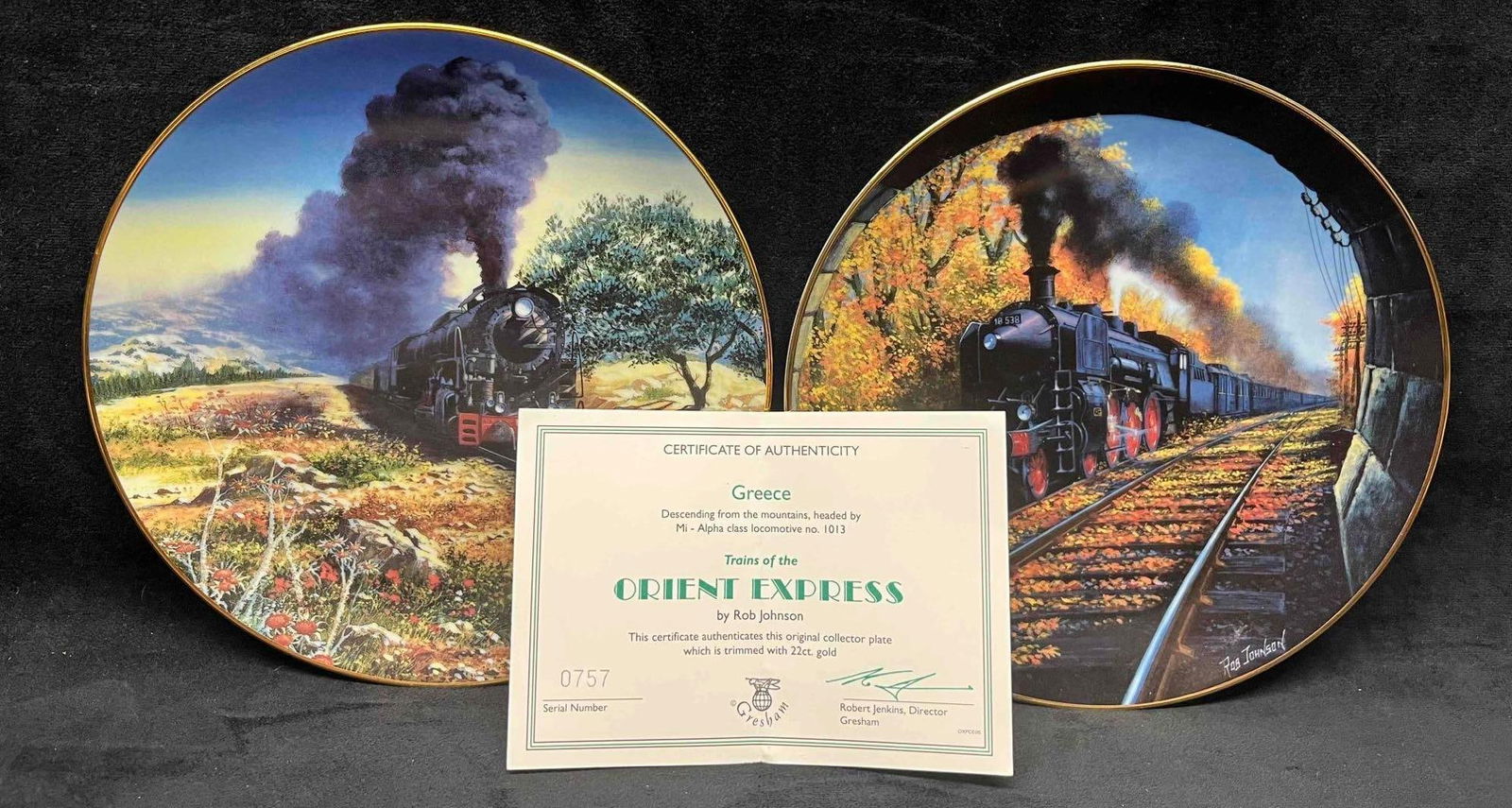 Two Porcelain Trains of The Orient Express Plates Edged in 22ct. Gold by Rob Johnson With COA: This lot contains Two Porcelain Trains of The Orient Express Plates Edged in 22ct. Gold by Rob Johnson With COA. Each plate is approx 8 1/4" x 8 1/4" x 1" and together they weigh about 1.4lbs.